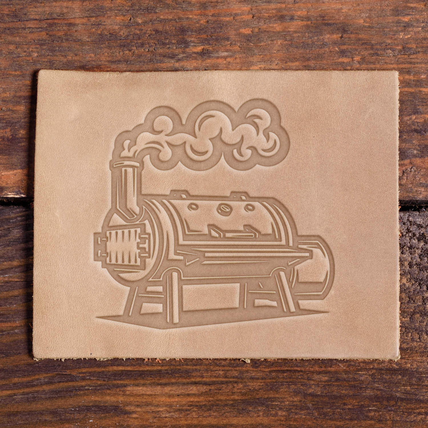 Leather sample with a stamped BBQ smoker design using a Delrin leather stamp, ideal for grilling or outdoor cooking-themed leather projects.
