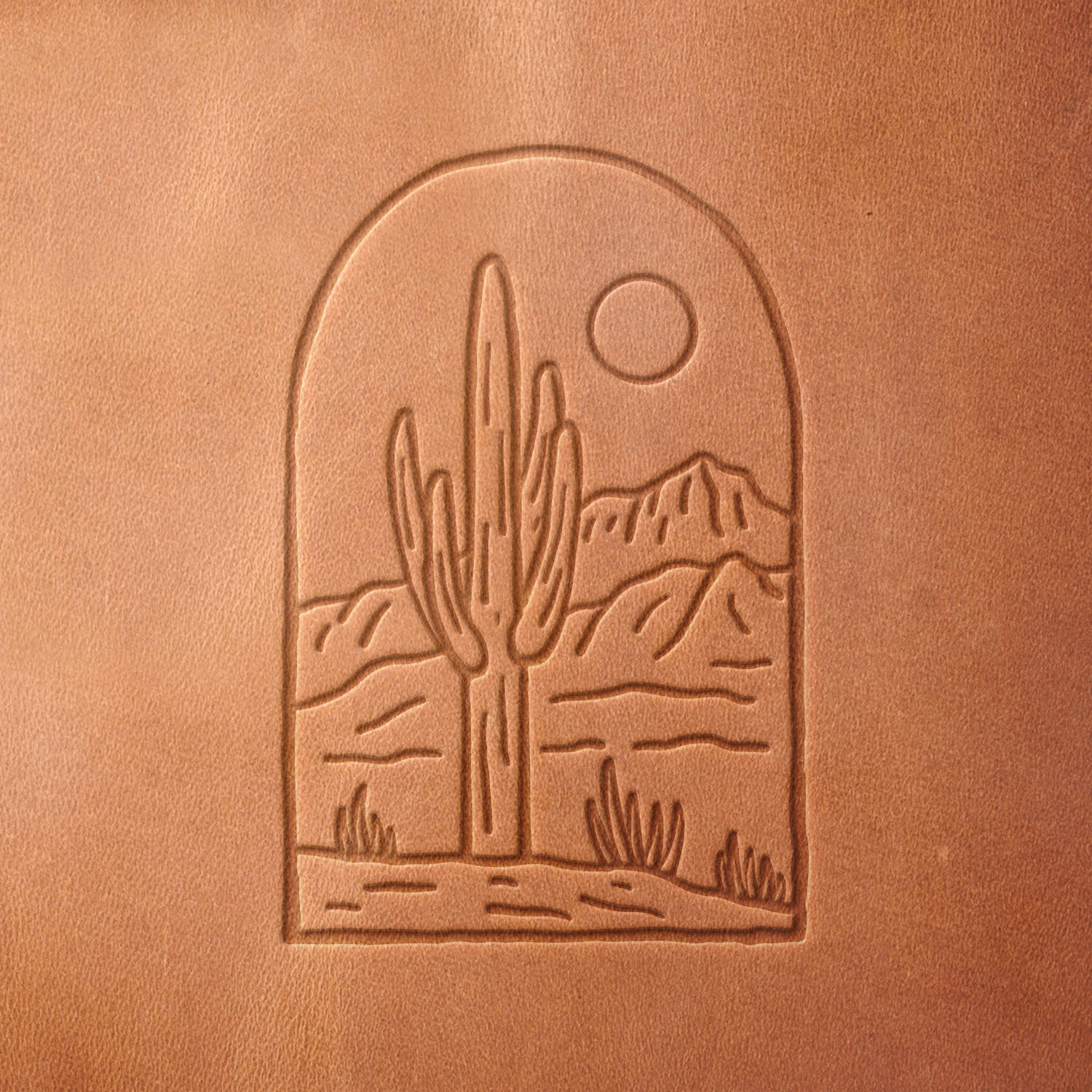 Leather sample with a crisp arched desert cactus and mountain landscape stamp impression from a Delrin leather stamp, ideal for creating high-quality southwestern and nature-themed leathercraft projects.