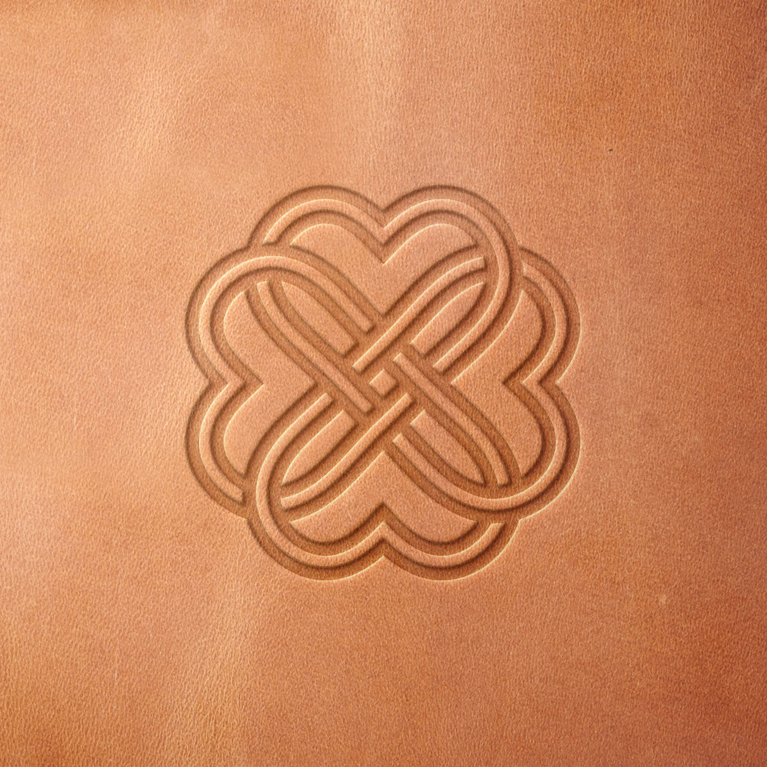 Leather sample stamped with a Delrin leather stamp, showcasing a Celtic knot with interwoven loops and a clover-shaped motif.