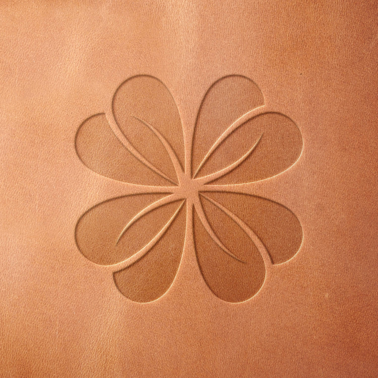 Leather piece stamped with a Delrin leather stamp of a four-petal abstract flower—adds a cheerful botanical touch to custom leather goods.