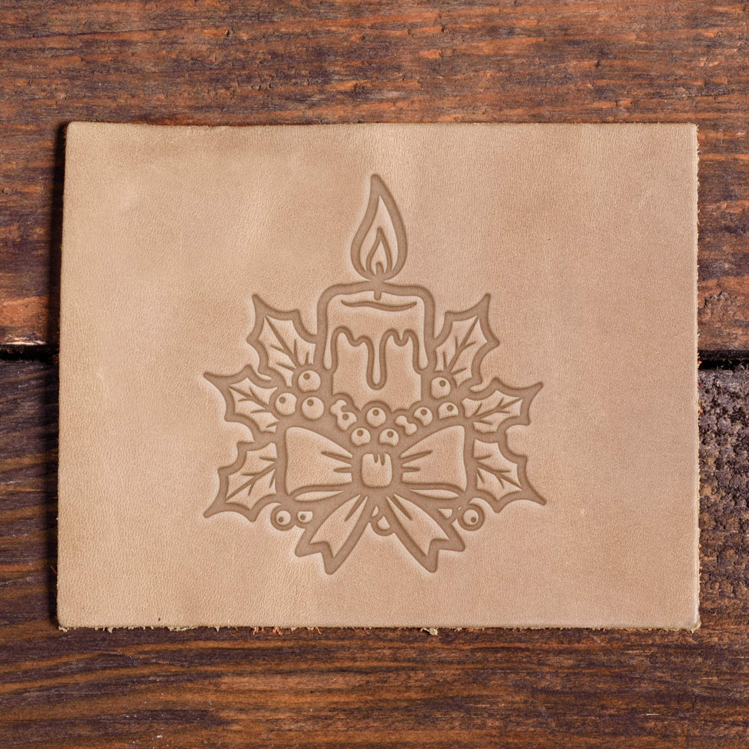 Leather sample with a stamped holiday candle design using a Delrin leather stamp, ideal for Christmas or winter-themed leather projects.