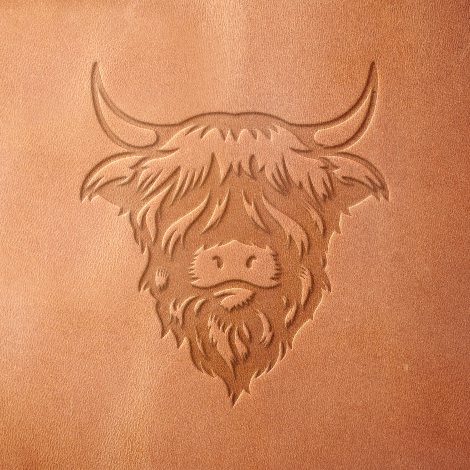 Leather piece stamped with a Delrin leather stamp of a fluffy highland cow head—great for western-style crafts, country gifts, or animal lover accessories.