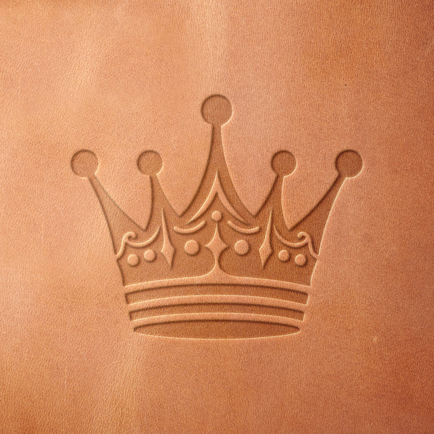 Leather sample featuring a stamped crown design using a Delrin leather stamp, highlighting intricate details and a classic royal motif.