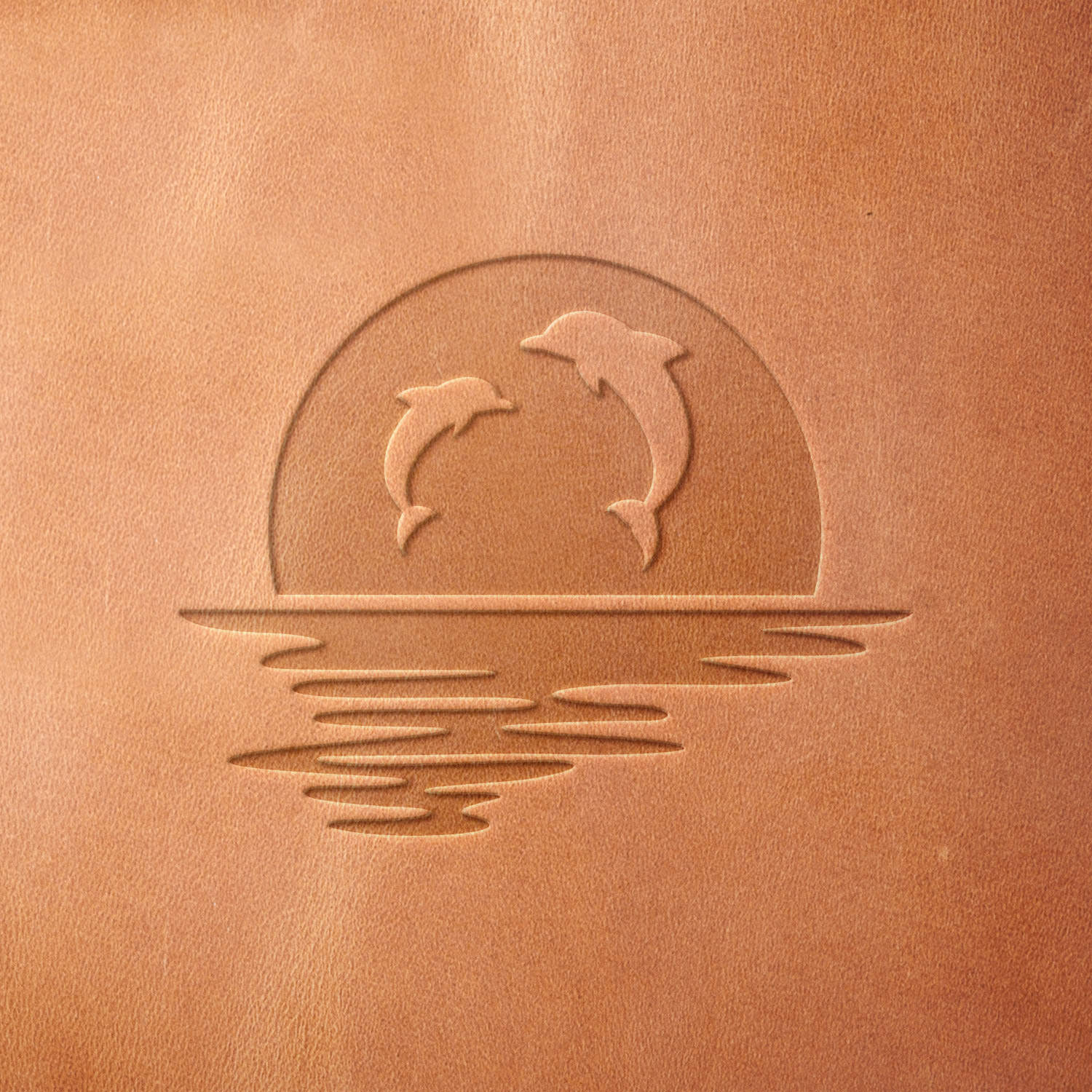 Leather piece stamped with a Delrin leather stamp featuring dolphins jumping at sunset—adds a coastal touch to handmade wallets, travel tags, or tropical decor items.