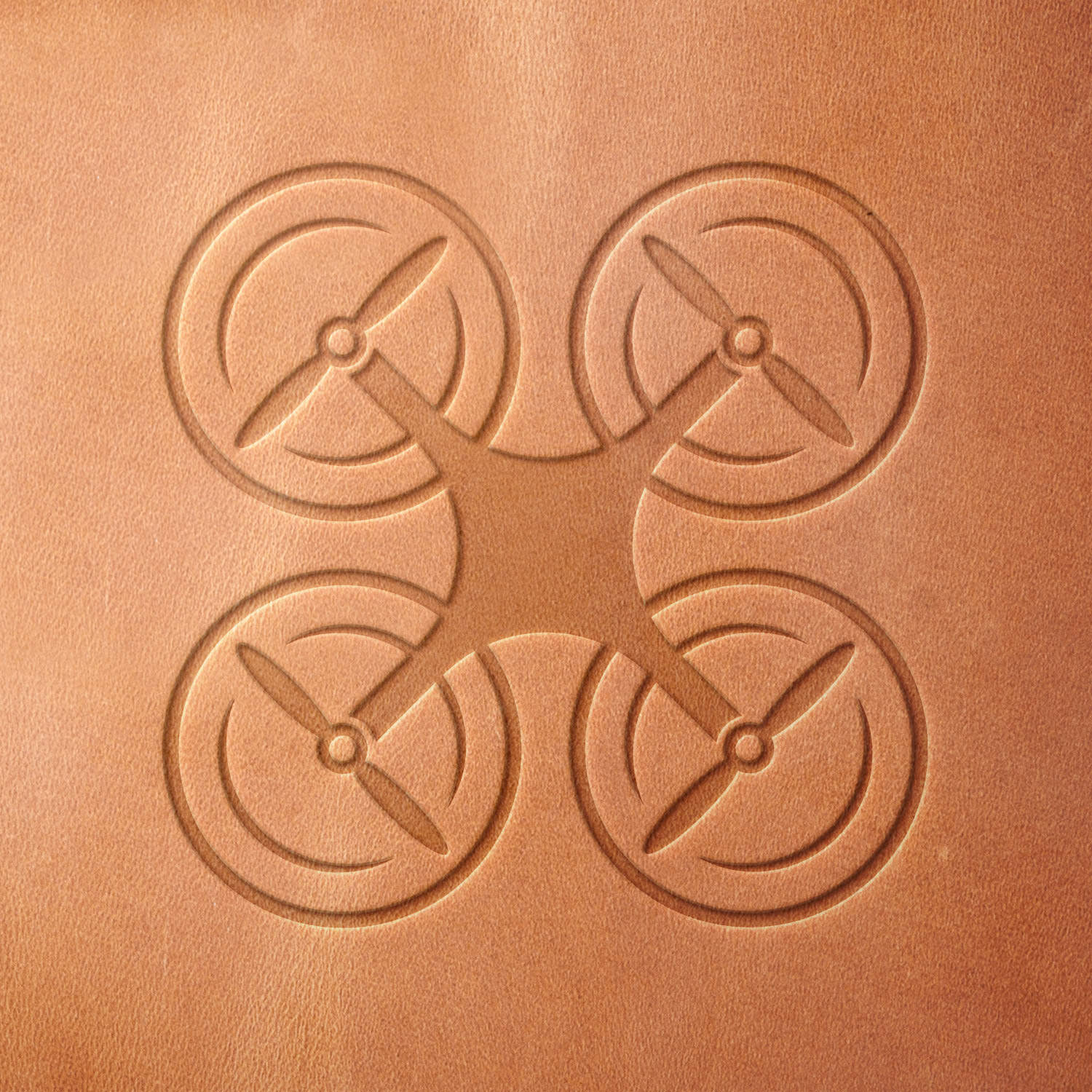 Leather piece stamped with a Delrin leather stamp of a quadcopter drone—ideal for drone case tags, maker projects, or hobbyist leatherwork.