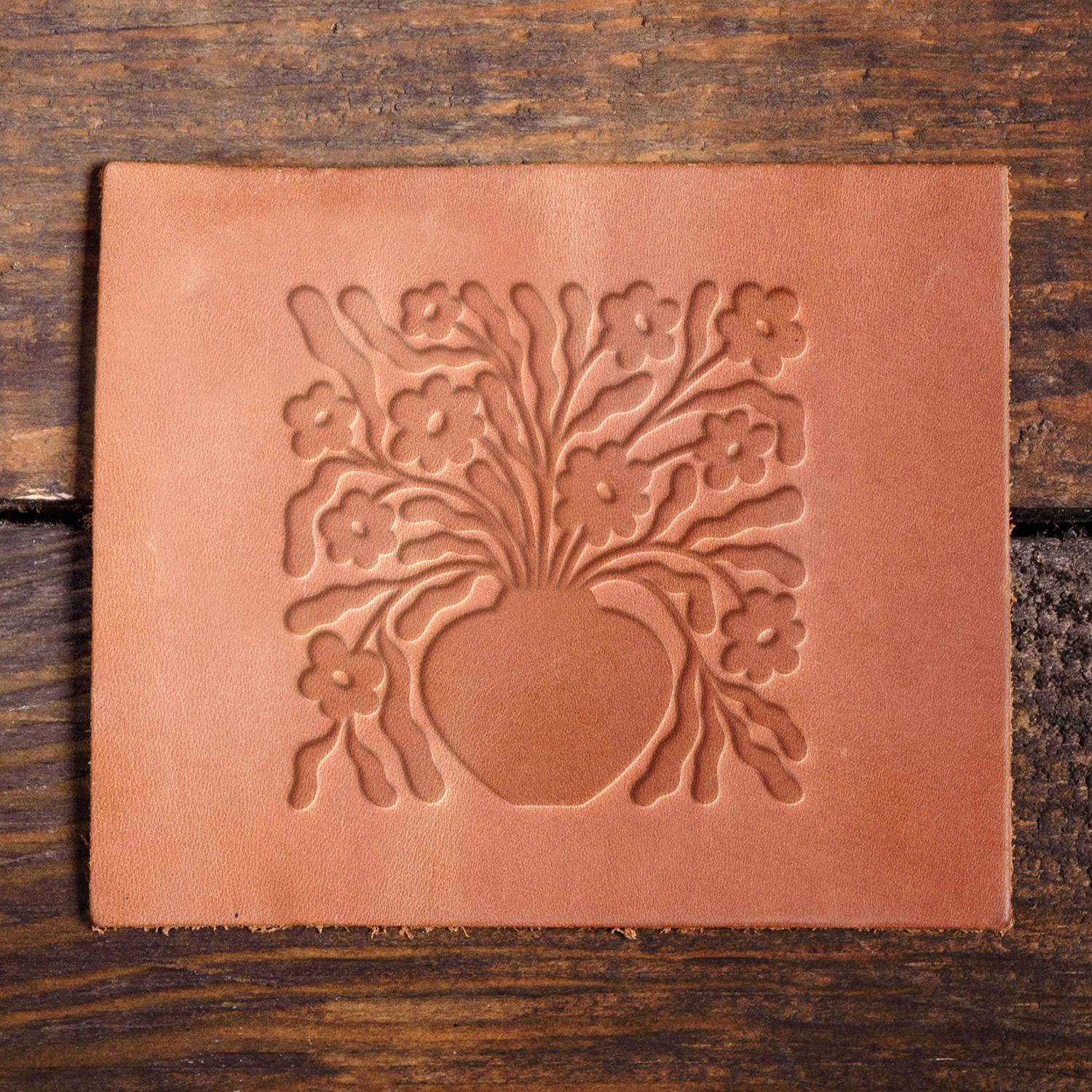 Leather sample with a crisp floral vase stamp impression from a Delrin leather stamp, ideal for creating high-quality botanical and decorative leathercraft projects.