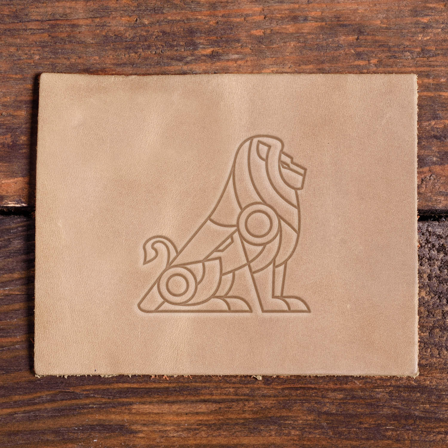 Stamped impression of a geometric lion made with a Delrin leather stamp on natural veg-tan leather.