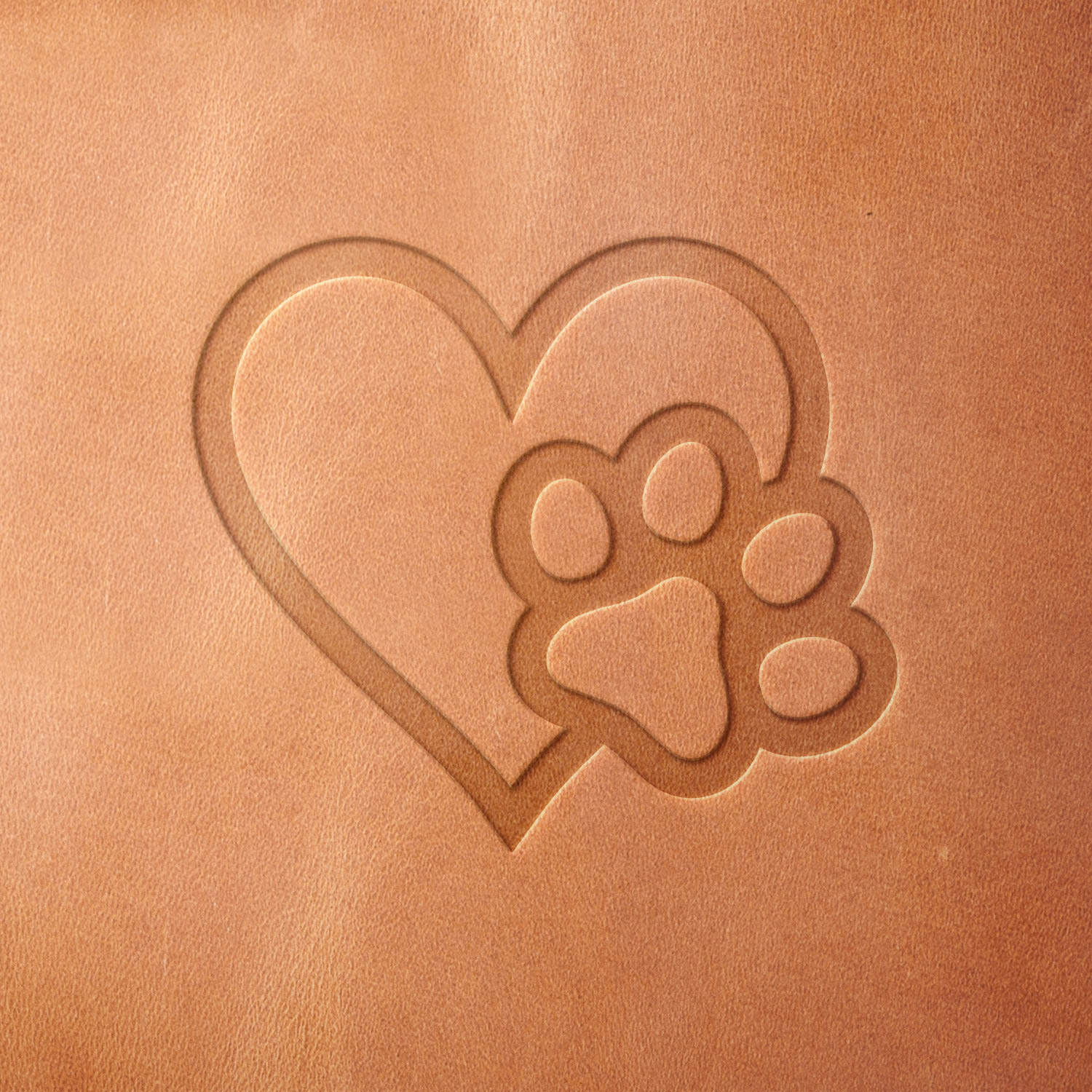 Leather piece stamped with a Delrin leather stamp showing a paw in a heart—great for honoring beloved pets or personalizing dog-themed leather accessories.
