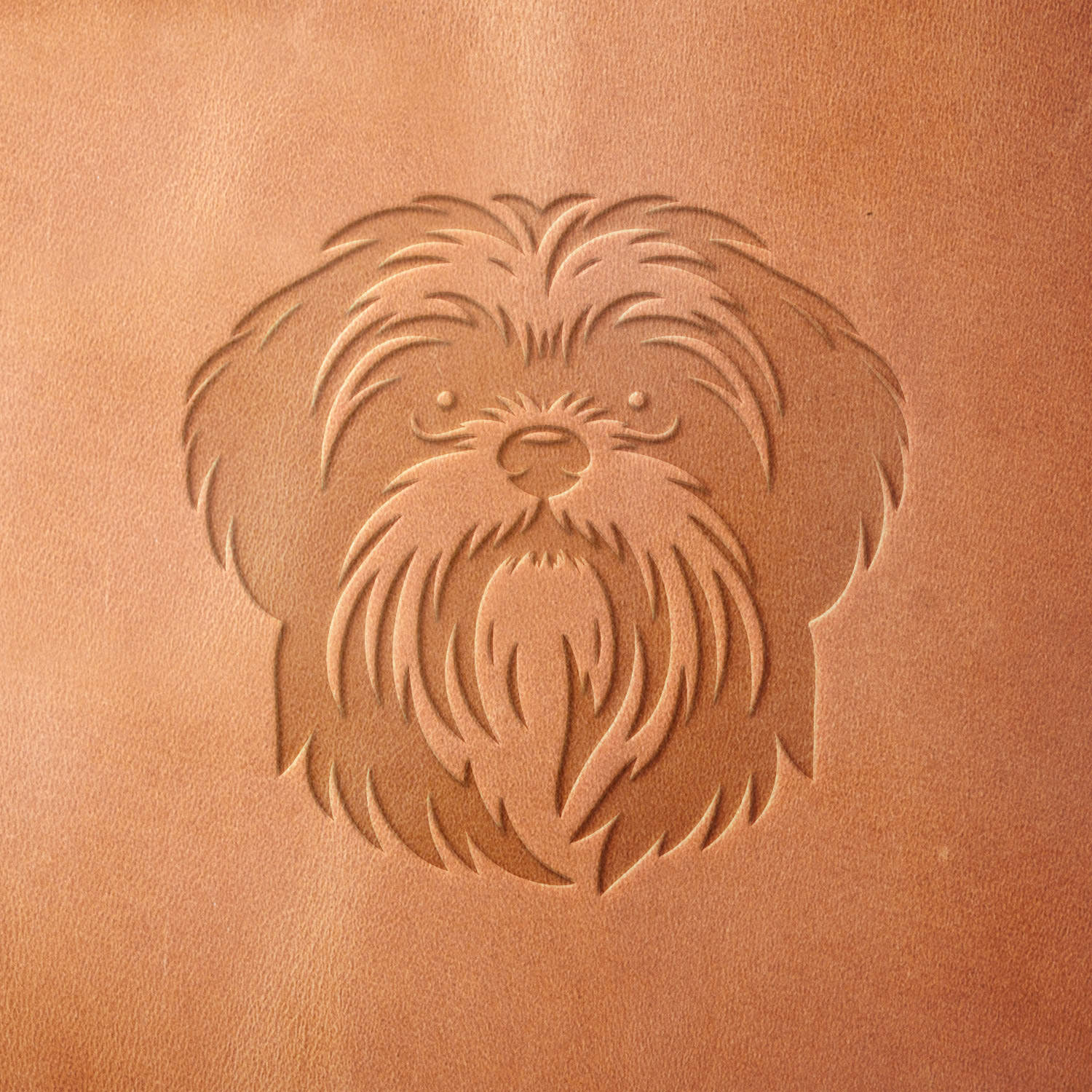 Leather piece stamped with a Delrin leather stamp of a Shih Tzu's face—ideal for personalized pet gear, dog lover gifts, or leather keychains.