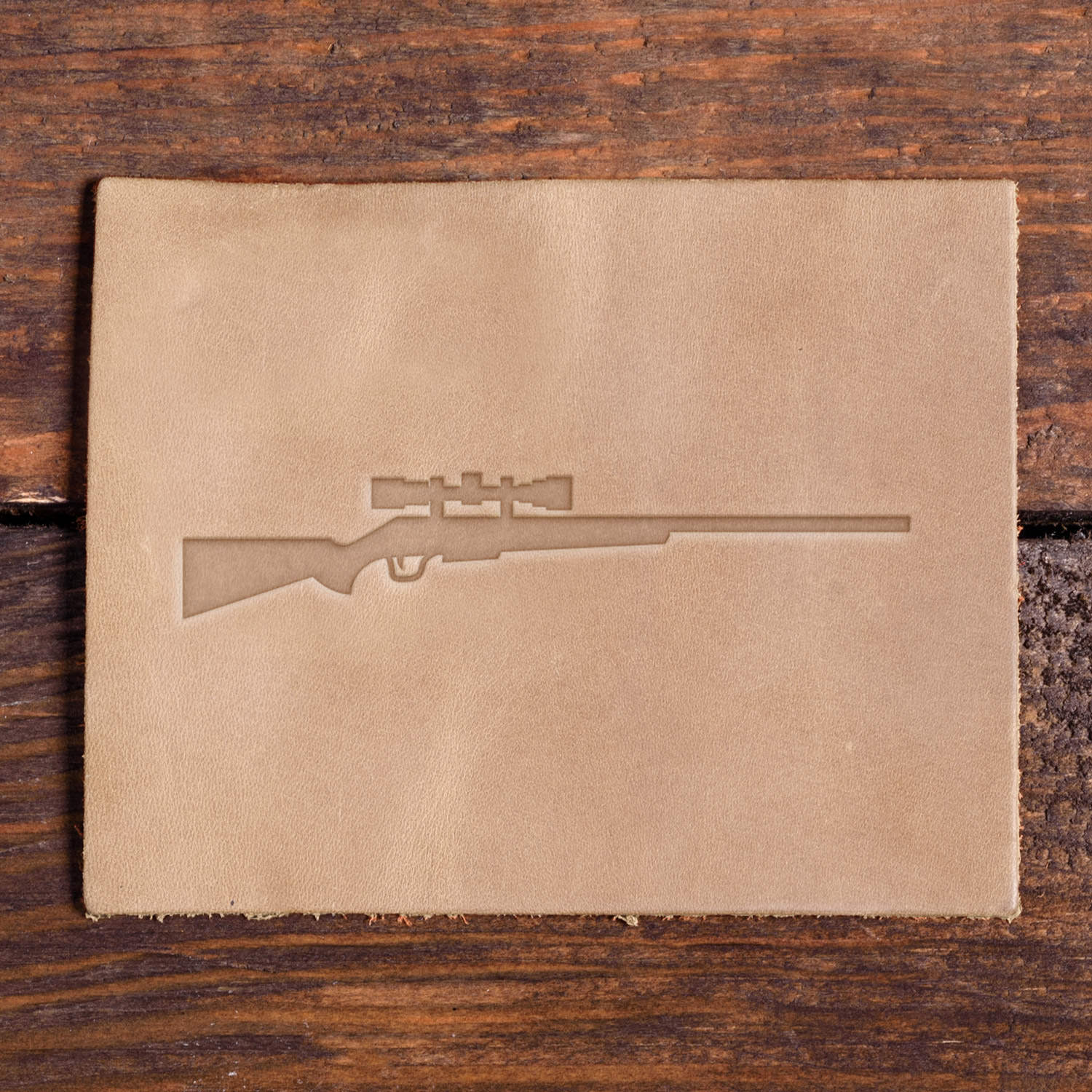 Leather sample with a stamped hunting rifle with a scope using a Delrin leather stamp.