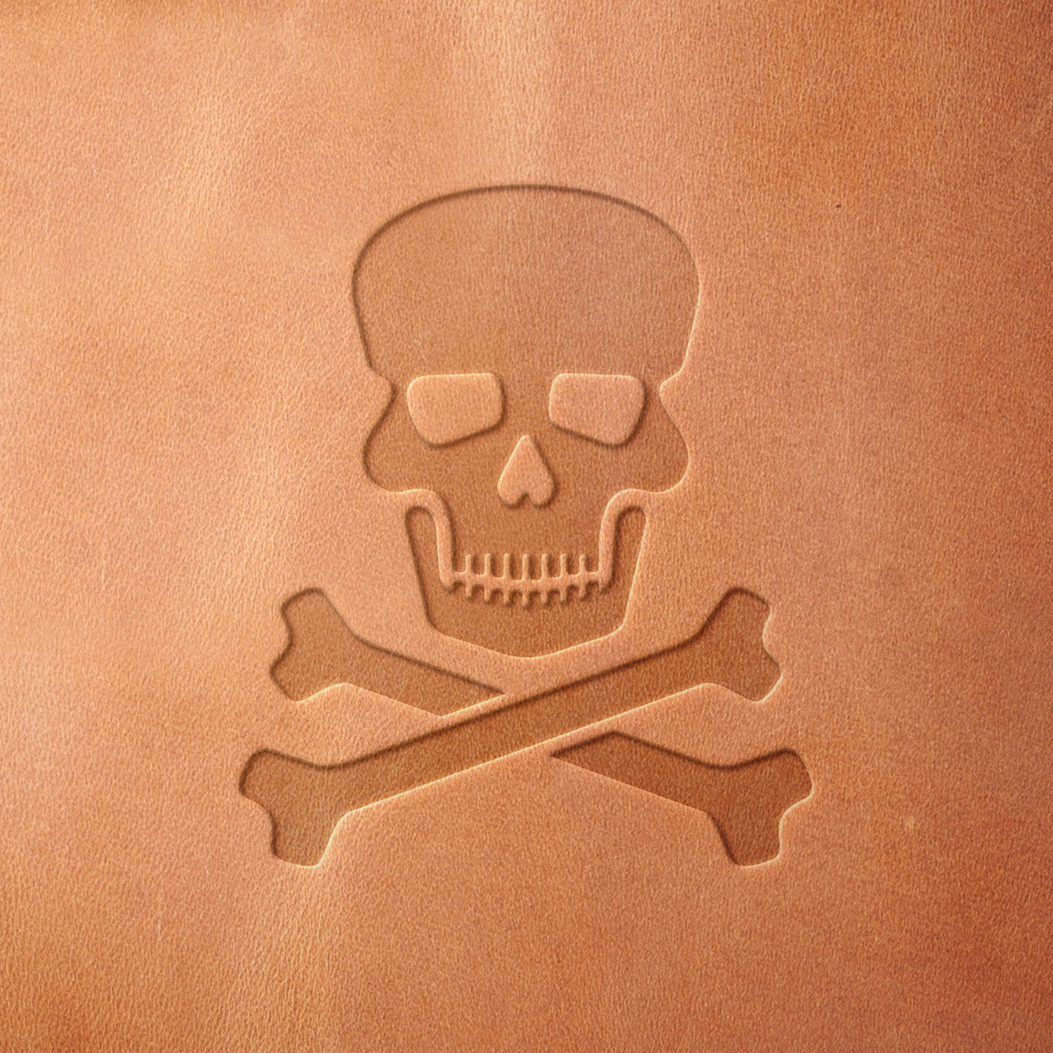 Leather piece stamped with a Delrin leather stamp of a skull and crossbones—ideal for rugged leather projects, pirate decor, or goth-inspired handmade goods.