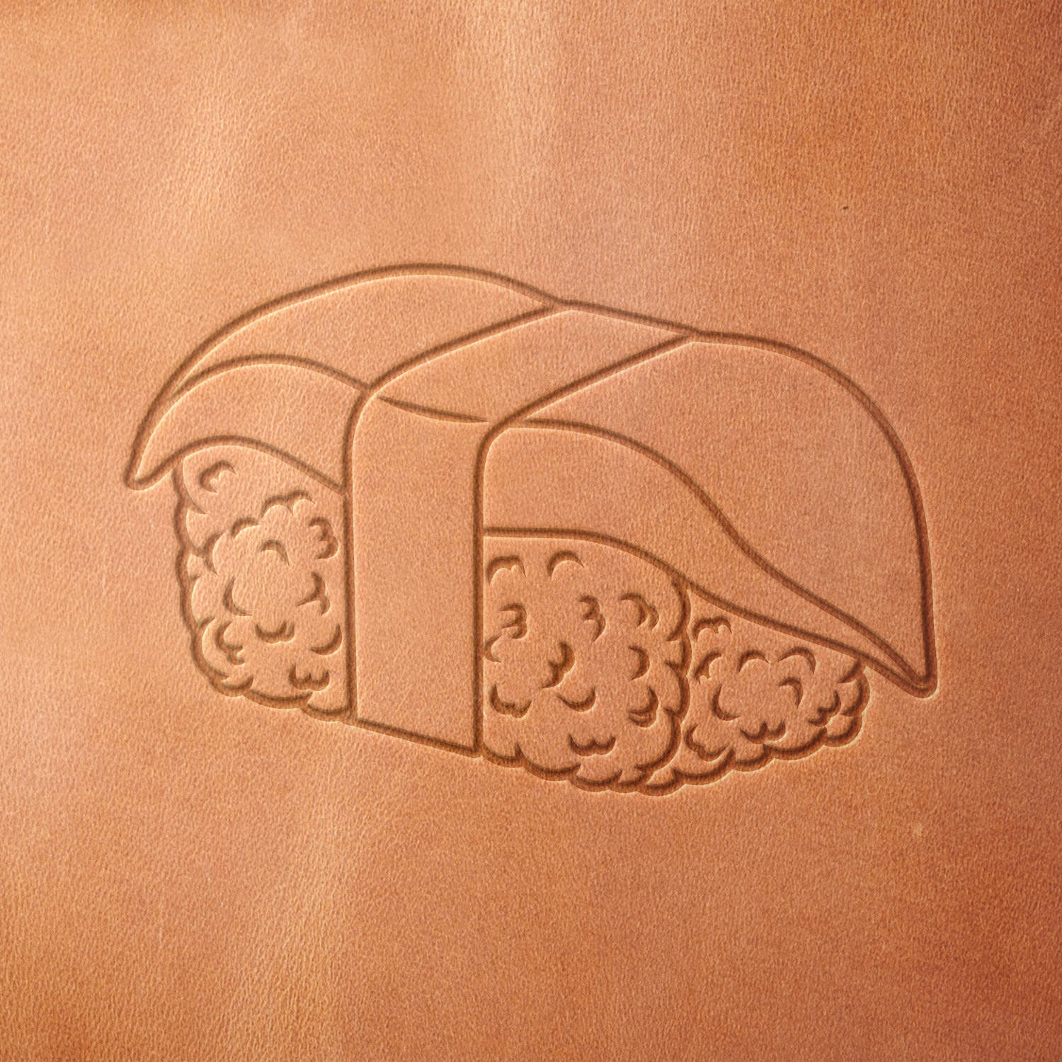 Leather piece stamped with a Delrin leather stamp of seaweed-wrapped sushi nigiri—adds a unique touch to chef gear, aprons, or food-themed gifts.