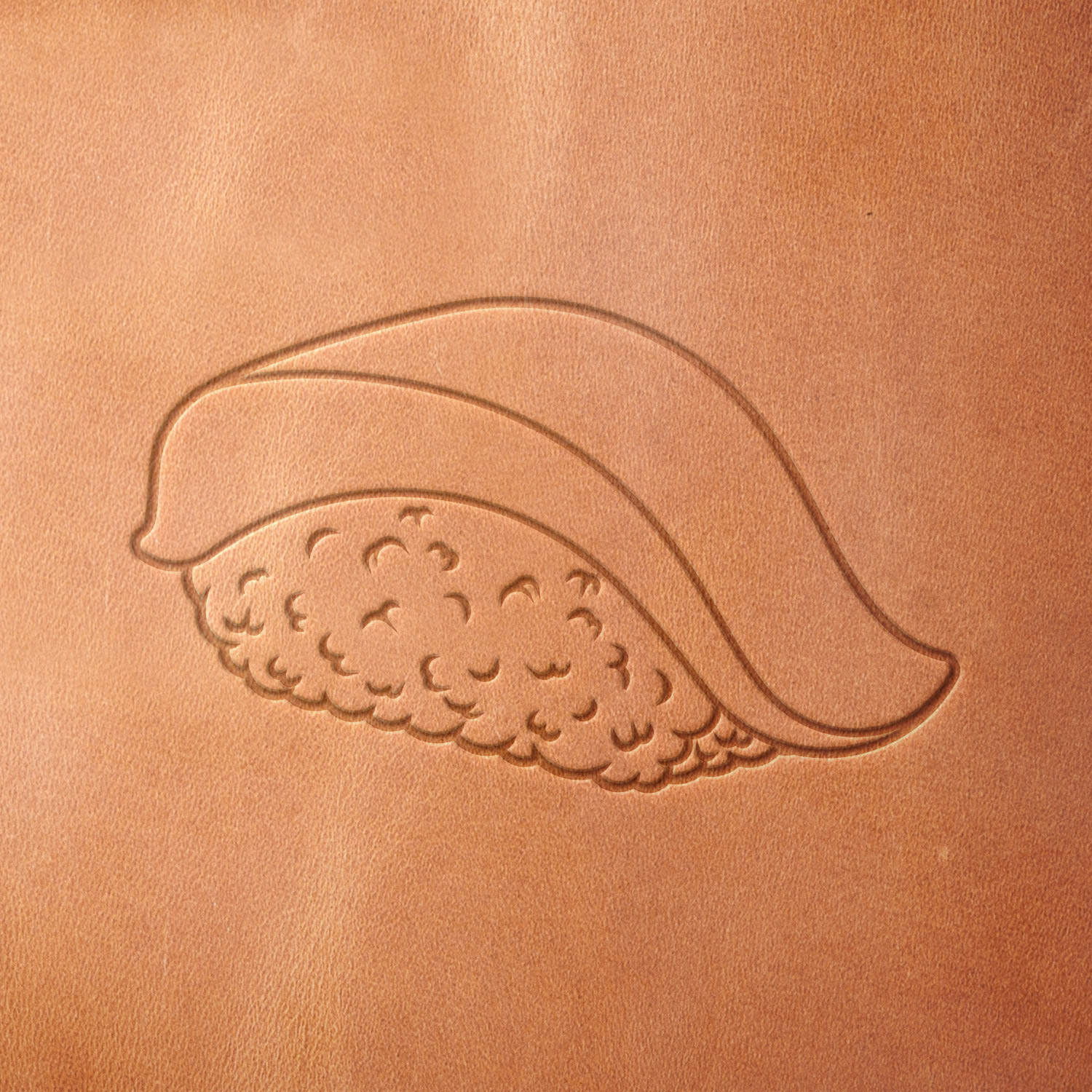 Leather piece stamped with a Delrin leather stamp of classic fish nigiri—great for customizing chef gear, restaurant accessories, or foodie-inspired leather goods.