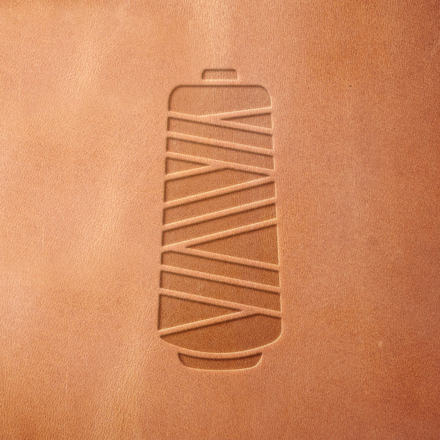 Leather piece stamped with a Delrin leather stamp of a thread spool—perfect for leather accessories, sewing studio decor, or handmade product branding.