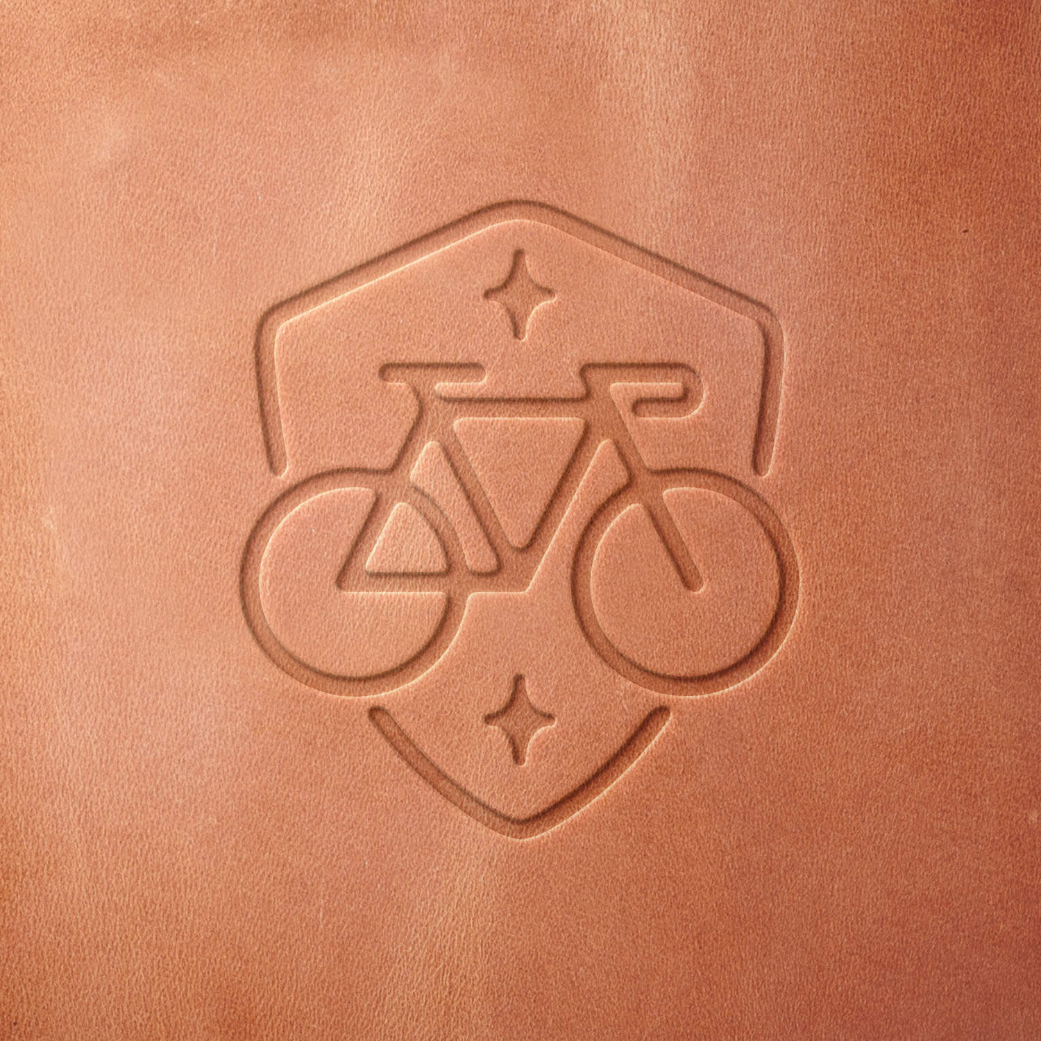 Leather sample featuring a stamped bicycle emblem, crafted using a Delrin leather stamp—ideal for cycling enthusiasts, bike shops, and adventure gear.