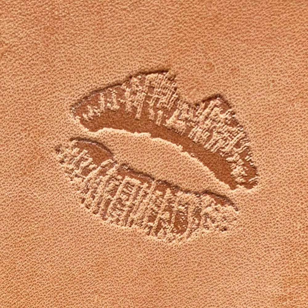 Stamped impression of textured lipstick kiss marks made with a Delrin leather stamp on natural veg-tan leather.