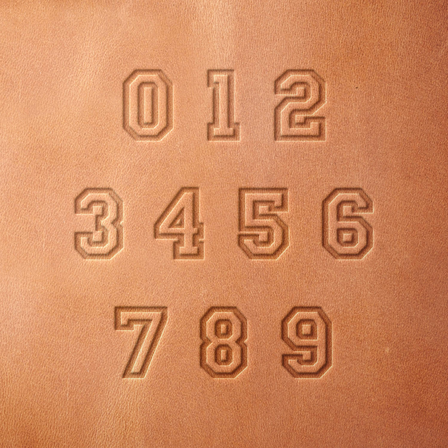 Leather piece stamped with a full set of varsity numbers using a Delrin leather stamp—perfect for customizing sports gear, team tags, or personalized leather goods.