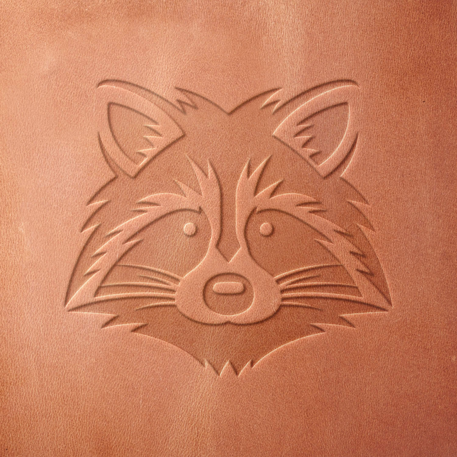 Leather sample featuring a stamped raccoon face, created using a Delrin leather stamp—perfect for wildlife, outdoor, and nature-inspired designs.