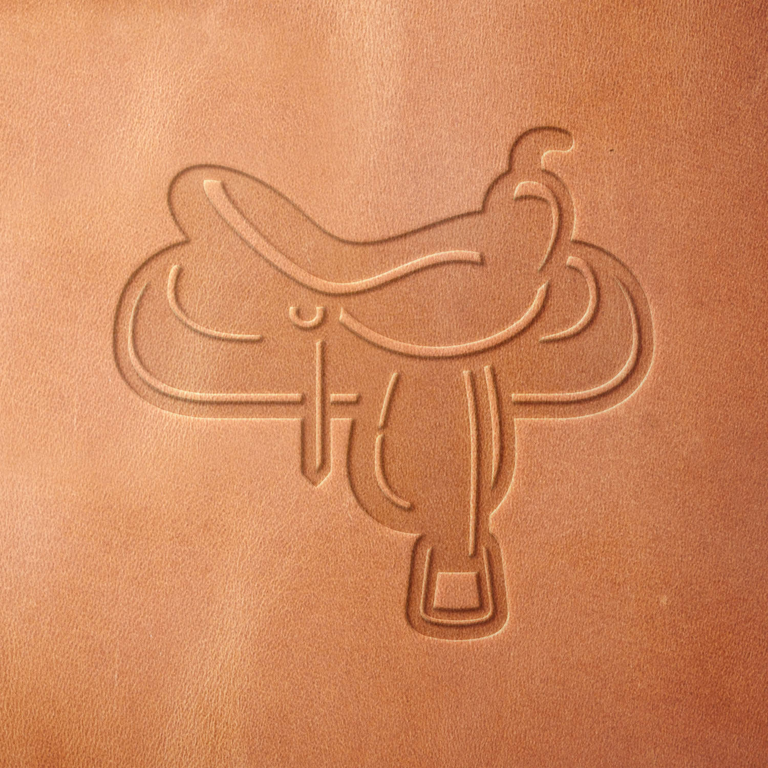 Leather sample with a stamped western saddle design, created using a Delrin leather stamp—ideal for horse lovers, ranchers, and leatherworkers crafting western-inspired pieces.