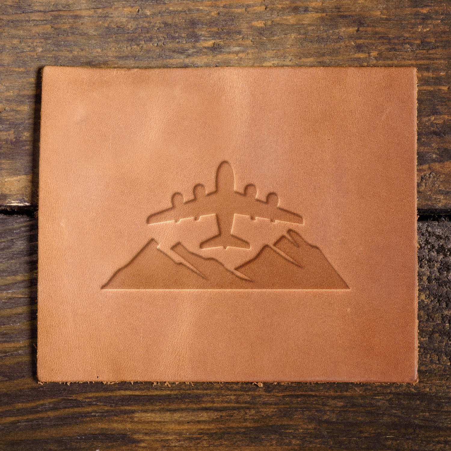 Leather sample with a crisp airplane and mountain stamp impression, adding a bold aviation-inspired touch to leather projects.