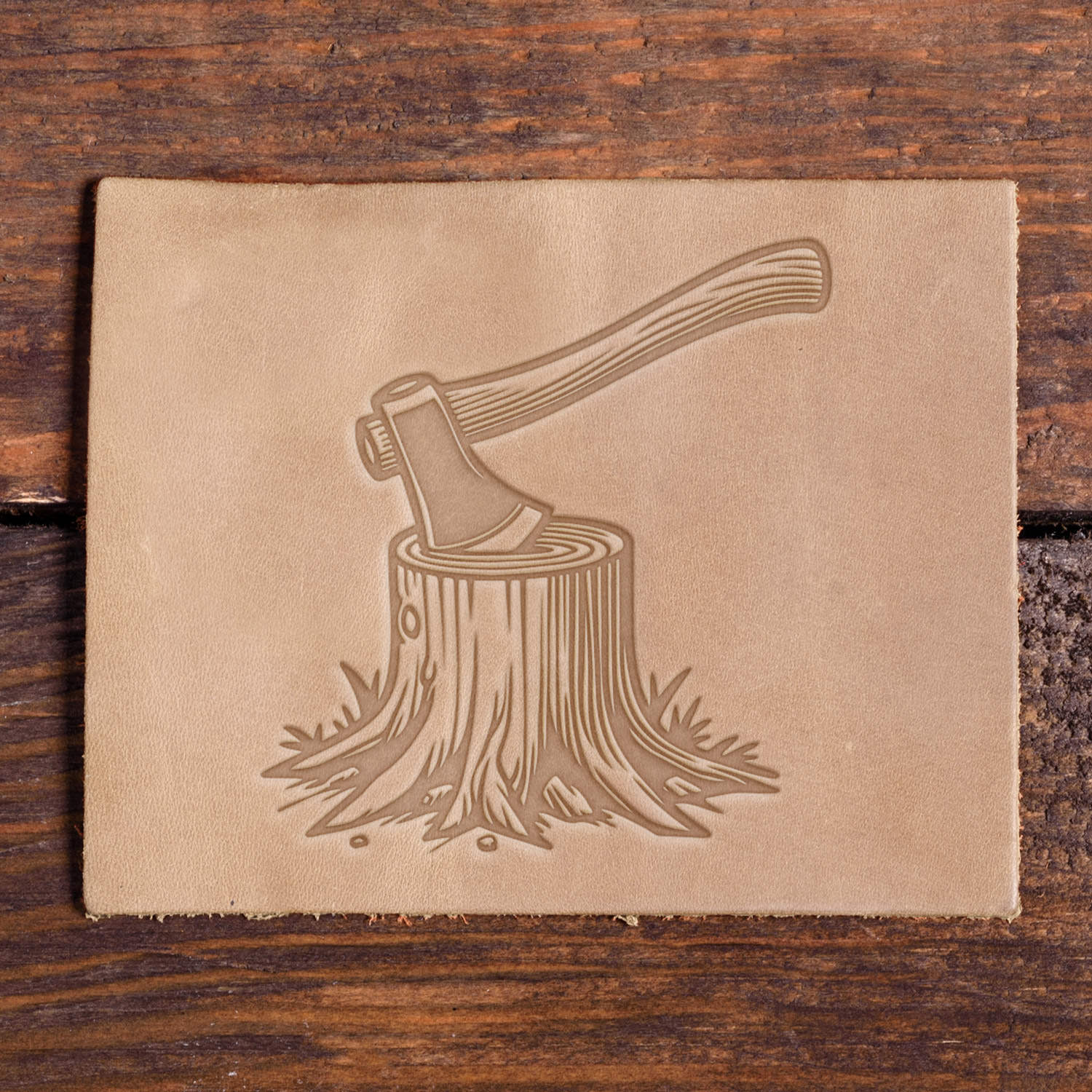 Leather stamped with axe in tree stump design using a Delrin stamp.