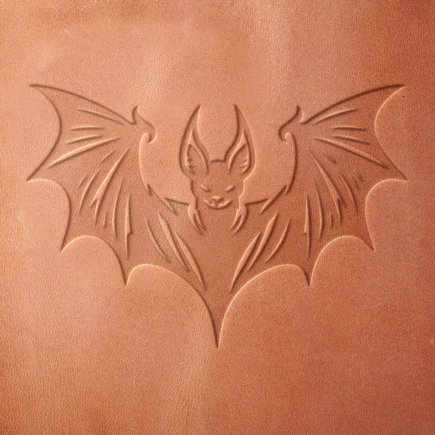 Leather impression of a striking bat design, pressed using a Delrin leather stamp. Showcases sharp wing details and a bold, symmetrical shape.