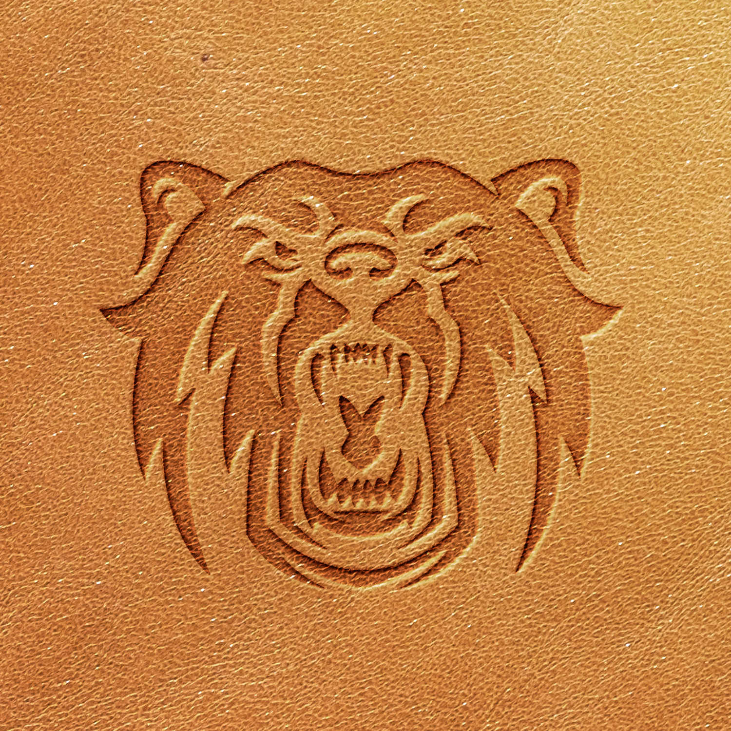 The Bear Delrin Leather Stamp imprints a fierce, embossed image of an angry bear, its mouth open and teeth bared. The stamp showcases detailed fur and sharp features on the bear's face, emphasizing its intense expression against a uniform, light brown leather surface.