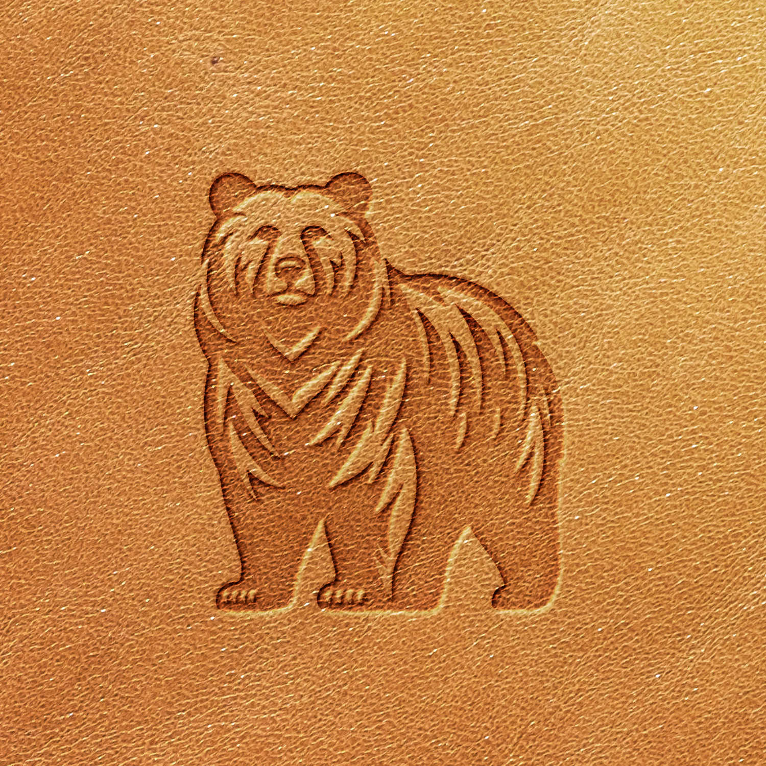 A detailed engraving of a bear is showcased on the Bear Delrin Leather Stamp, featuring an image of the bear in a standing position with fine lines highlighting the texture of its fur against a light brown leather background.