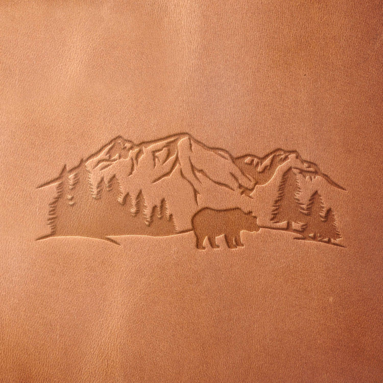 Leather sample with a crisp mountain landscape and bear stamp impression from a Delrin leather stamp, ideal for creating high-quality nature and outdoor-themed leathercraft projects.