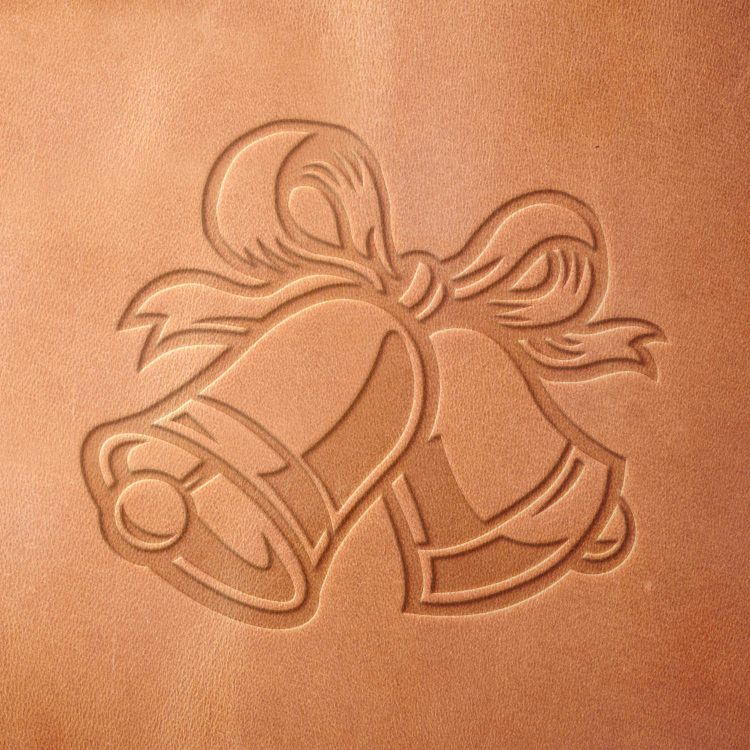 Leather sample showcasing a stamped holiday bells design using a delrin leather stamp, highlighting the curved bell shapes and flowing ribbon details.