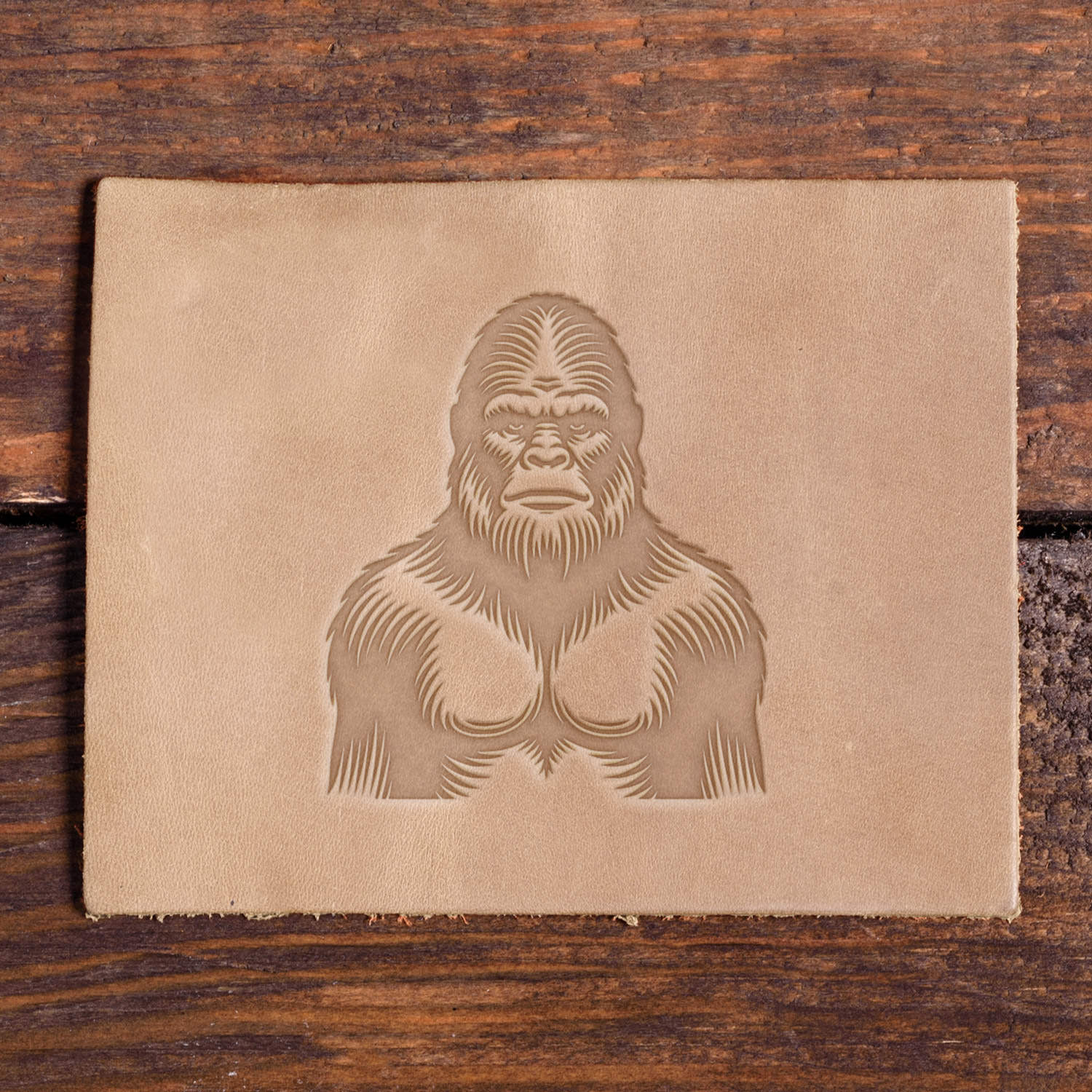 Leather piece stamped with a Delrin leather stamp design of Bigfoot, showing a detailed furry texture and powerful upper body.
