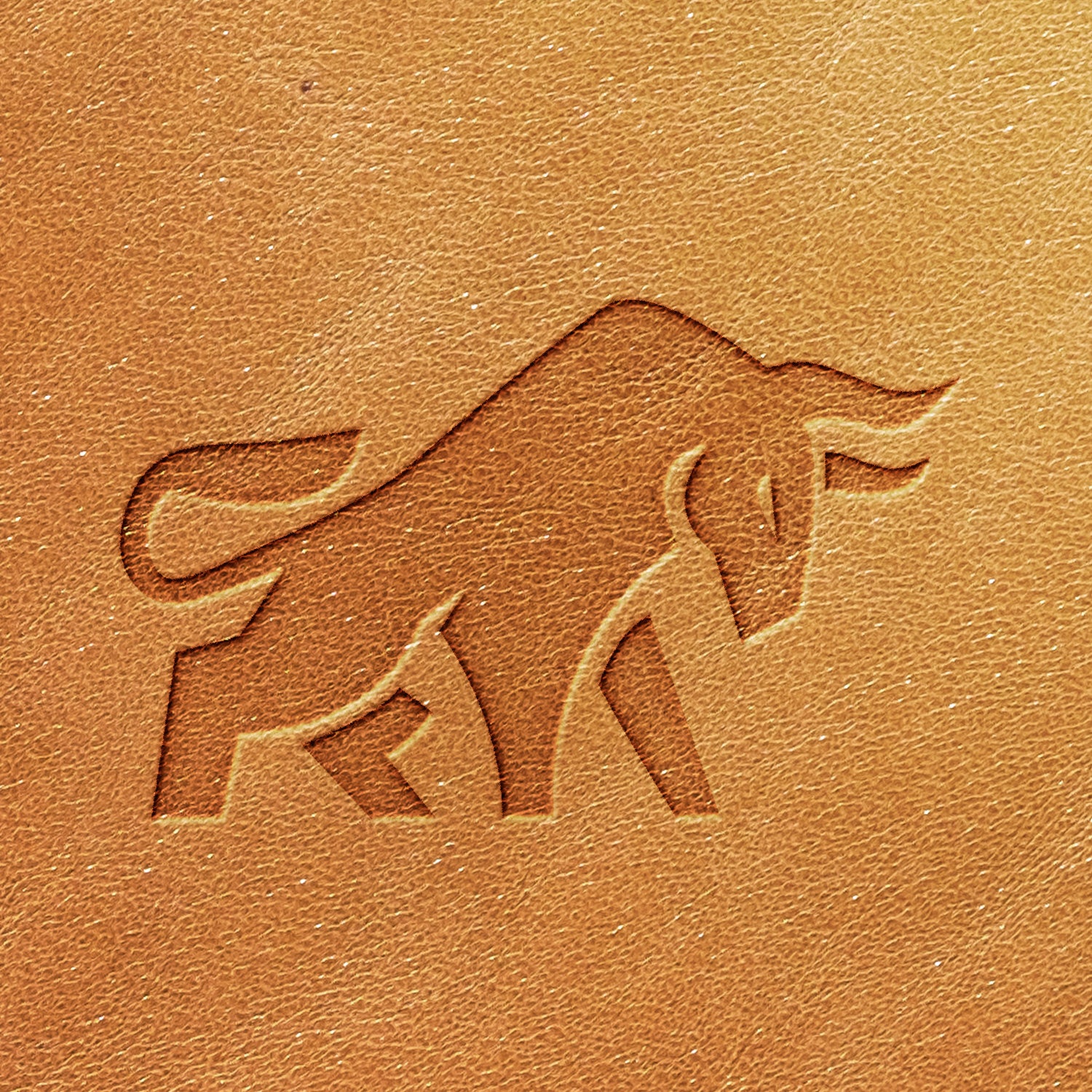 The Bull Delrin Leather Stamp features a stylized image of a bull embossed on a textured piece of brown leather. The bull, depicted in a minimalist and angular design, appears to be in a charging stance.