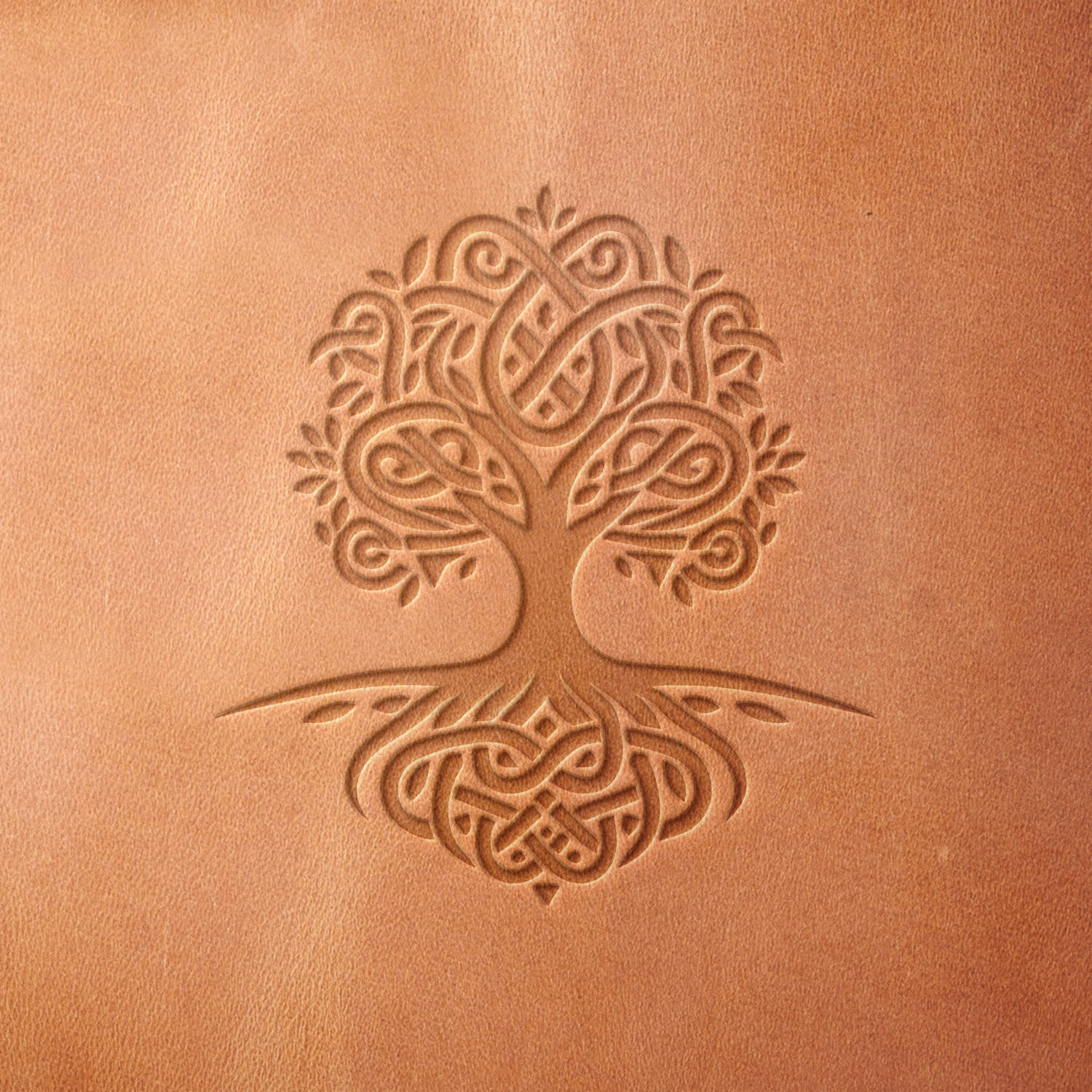 Leather sample stamped with a Delrin leather stamp, showcasing a Celtic tree of life with detailed knotwork and organic symmetry.