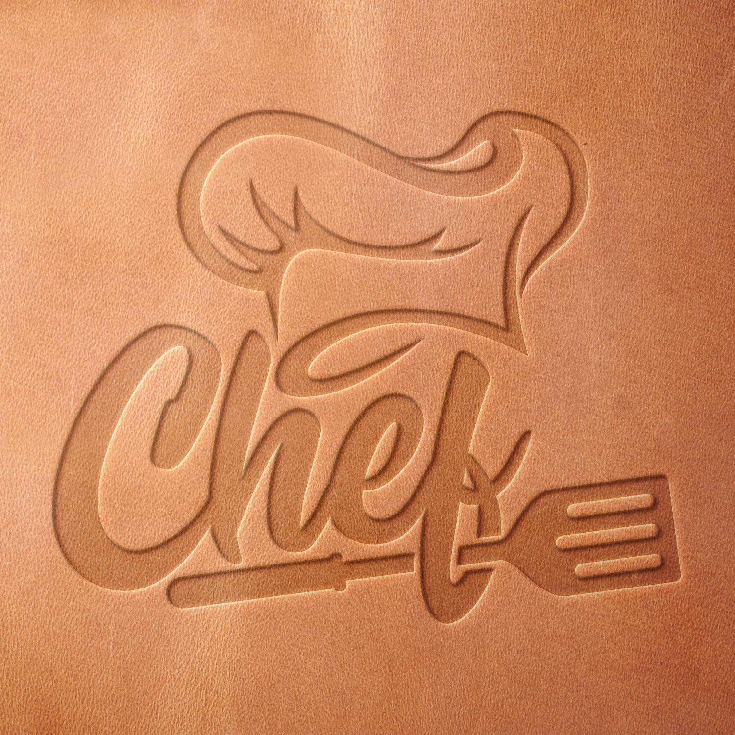 Leather sample showcasing a stamped chef design using a delrin leather stamp, highlighting the hat’s contours, flowing text, and spatula detail.