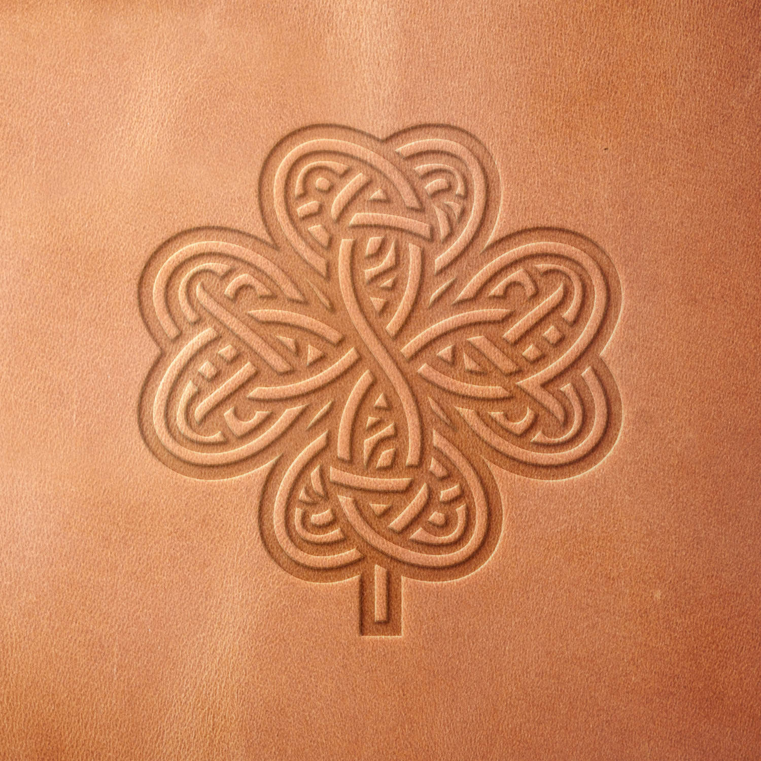 Leather sample stamped with a Delrin leather stamp, showcasing a Celtic knot clover with detailed interwoven loops and a central stem.