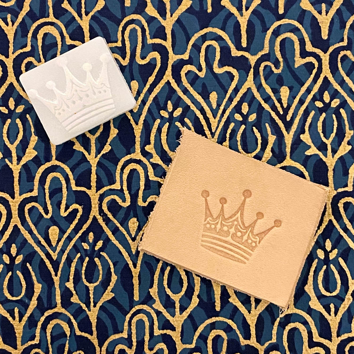 Leather sample featuring a stamped crown design using a Delrin leather stamp, highlighting intricate details and a classic royal motif.
