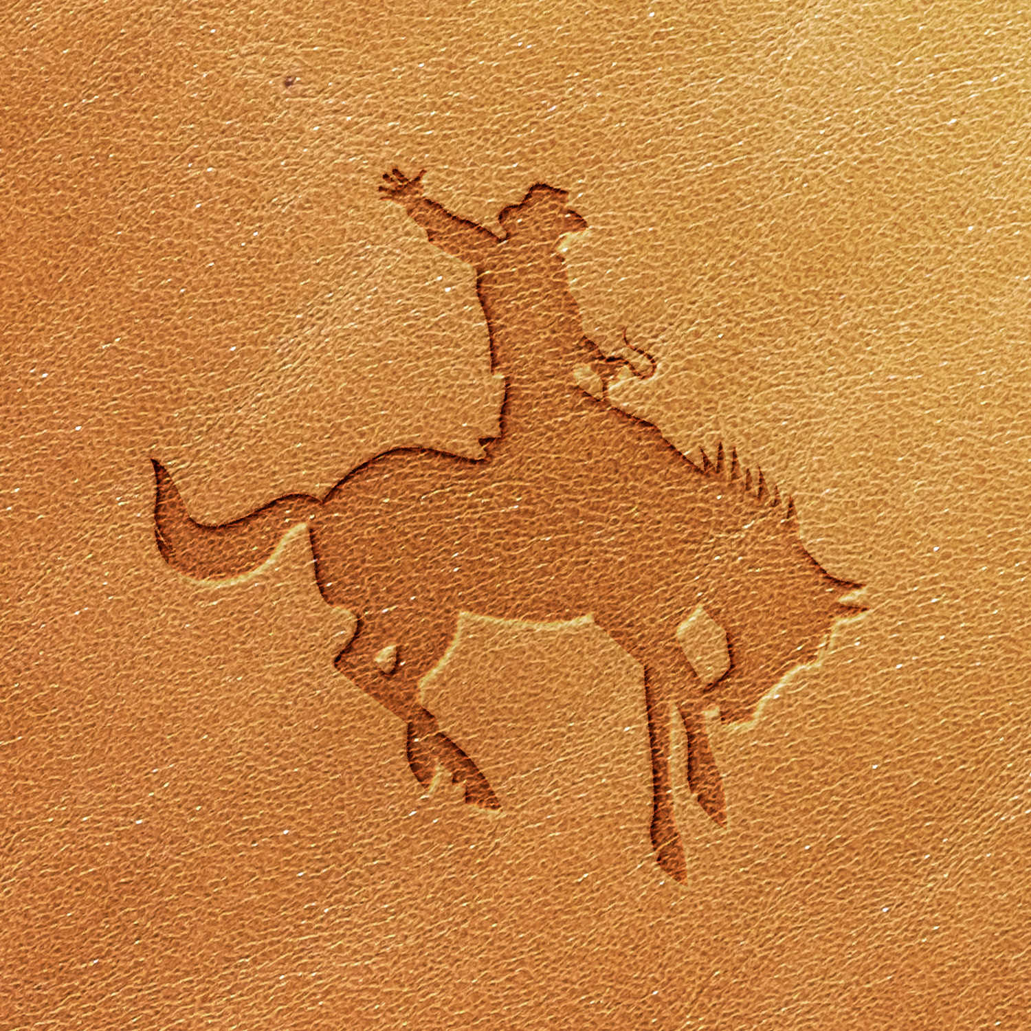 The Cowboy Delrin Leather Stamp features an embossed silhouette of a rodeo cowboy riding a bucking horse. The cowboy has one arm raised, and the design is simple, with clean lines outlining the figures.