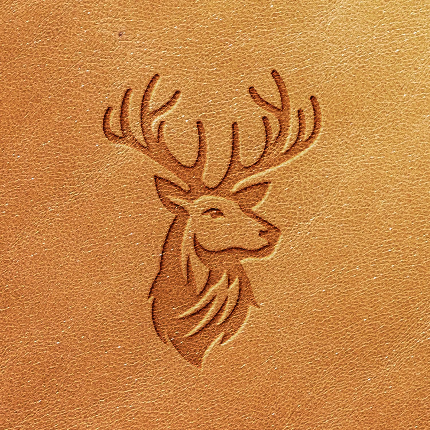 A stylized image of a deer's head and antlers is embossed onto light brown leather using the Deer Delrin Leather Stamp. The design is simple, featuring smooth lines that give a modern and clean look to the engraving.