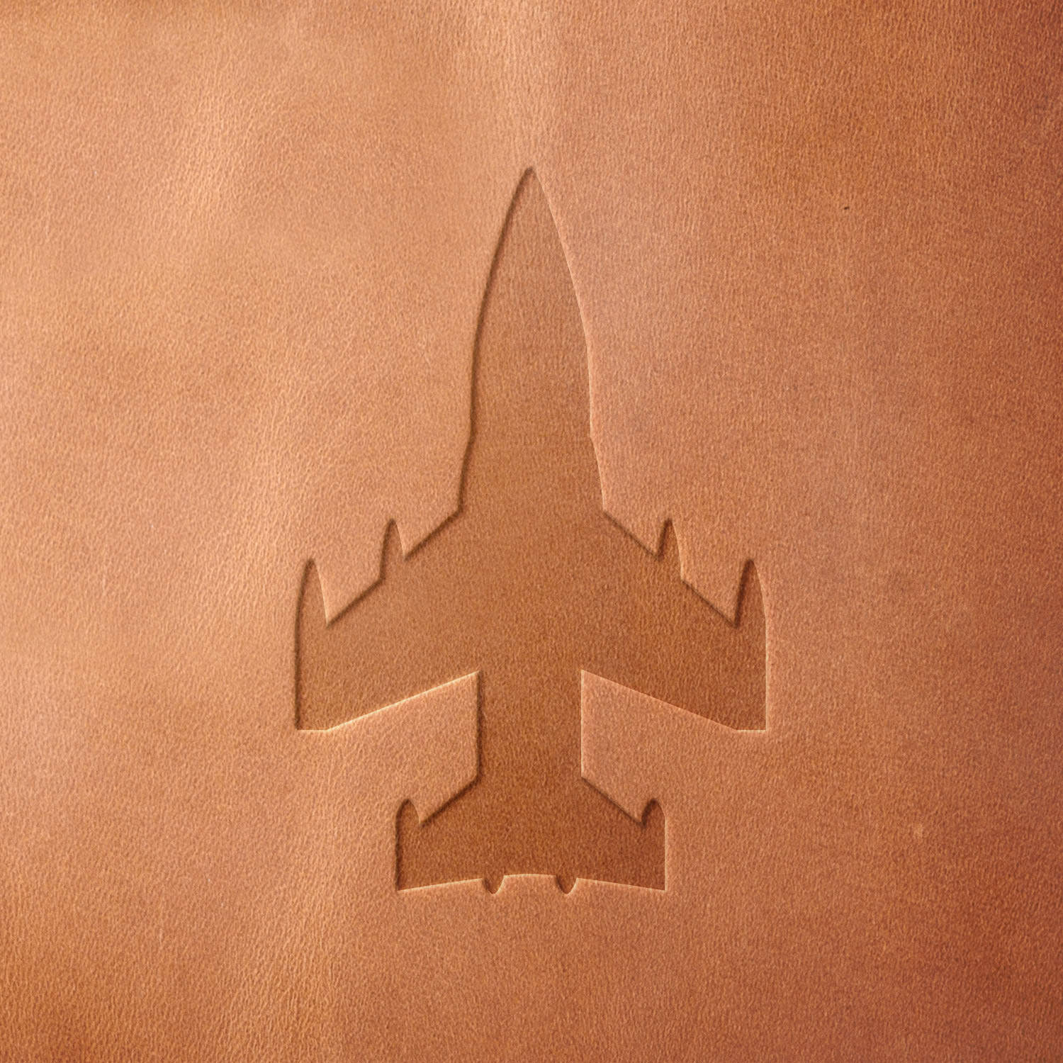 Leather sample with a crisp fighter jet stamp impression from a Delrin leather stamp, ideal for creating high-quality aviation and military-themed leathercraft projects.