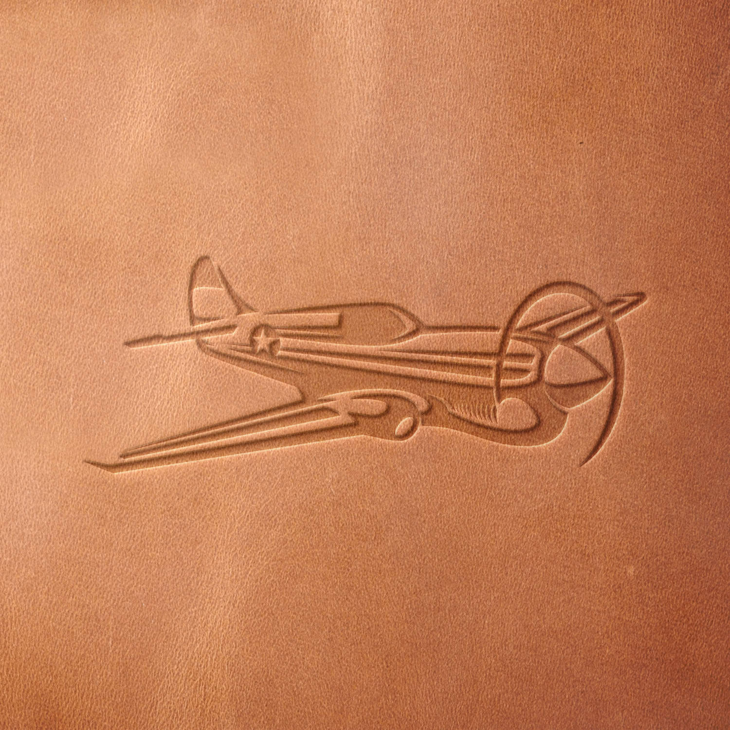 Leather sample with a crisp vintage propeller airplane stamp impression from a Delrin leather stamp, ideal for creating high-quality aviation and travel-themed leathercraft projects.