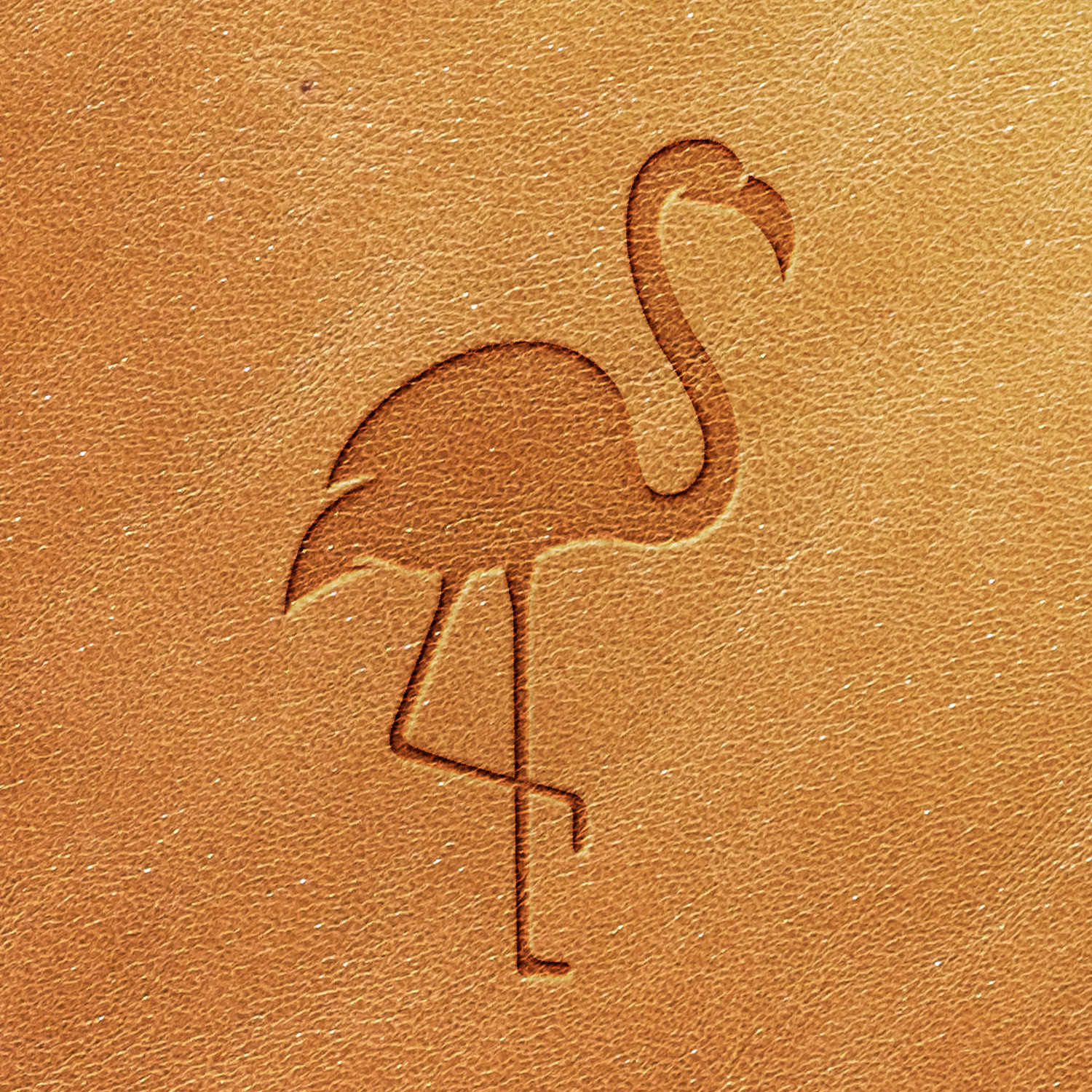 The Flamingo Delrin Leather Stamp features a clean, minimalistic design of a stylized flamingo engraved on tan leather. The depiction shows the flamingo standing on one leg with its neck slightly curved.