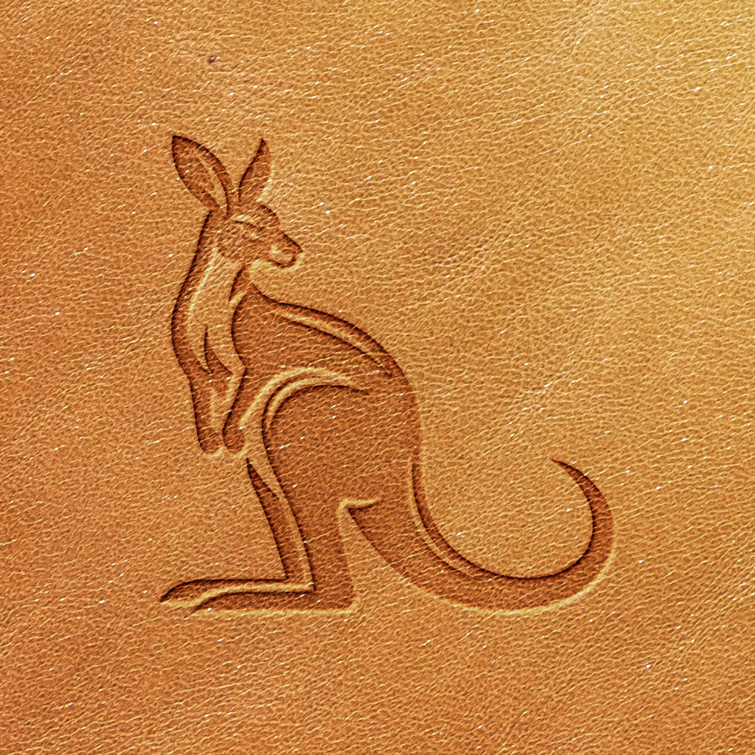 The Kangaroo Delrin Leather Stamp features a stylized silhouette of a kangaroo embossed on a light brown leather surface. The design boasts clean lines and offers a minimalistic depiction of the animal, presenting it in a side-facing, upright stance.