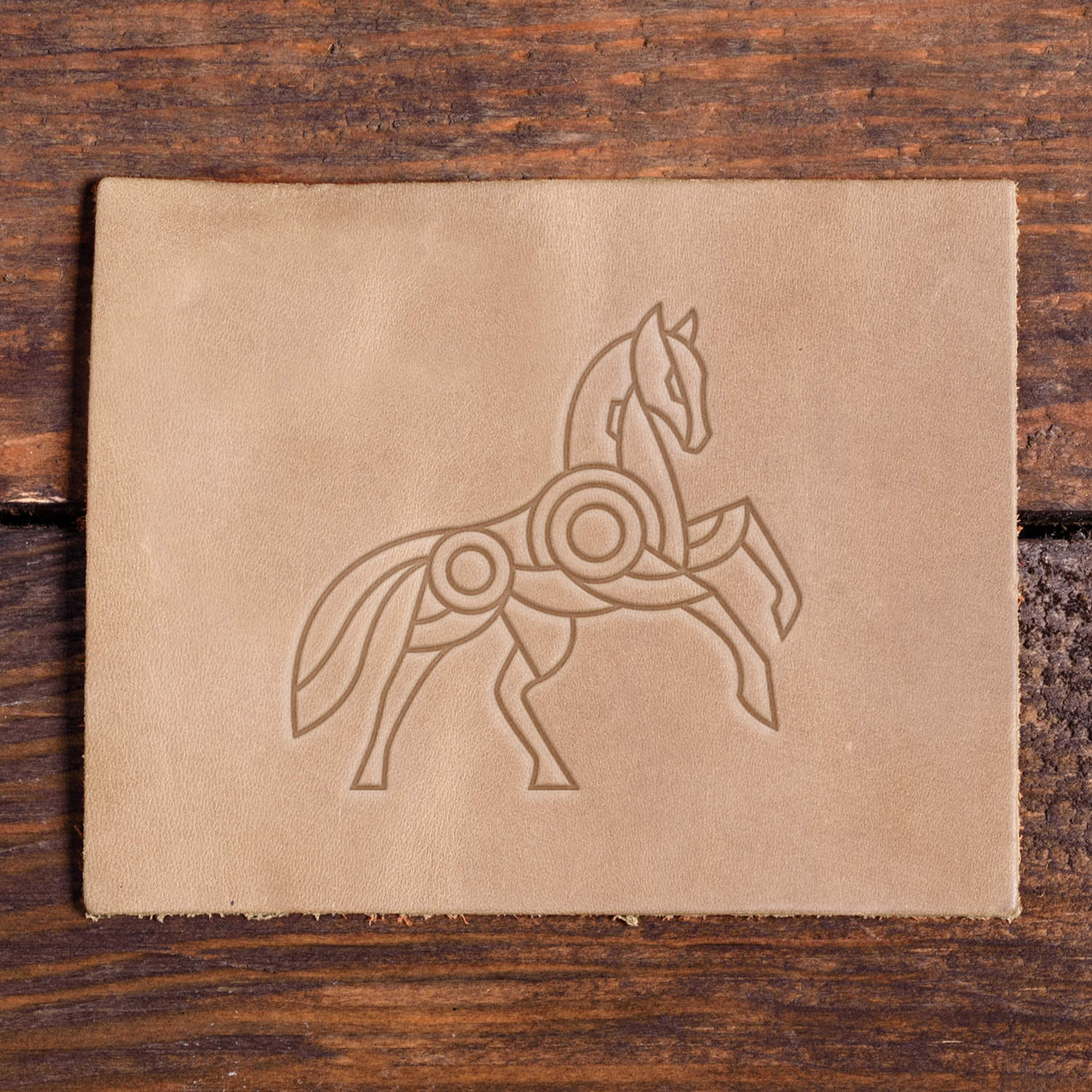 Stamped impression of a geometric horse in motion made with a Delrin leather stamp on natural veg-tan leather.