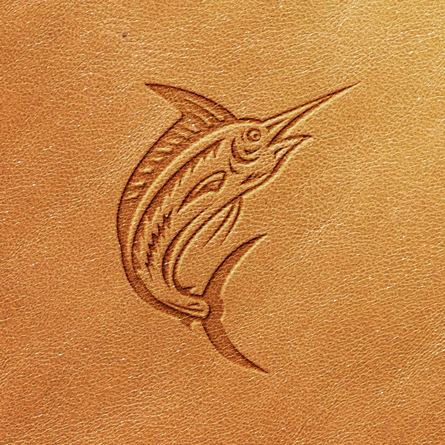 An image showcasing the Marlin Delrin Leather Stamp, featuring an embossed illustration of a marlin on tan-colored leather. The marlin is depicted with a streamlined body, long bill, and prominent dorsal fin, giving it a dynamic, upward-facing appearance.