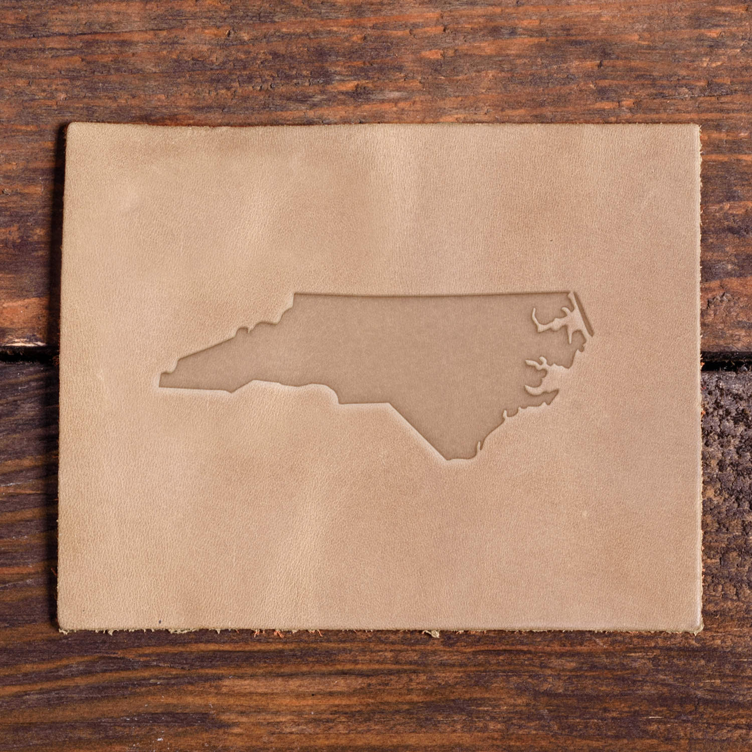 Leather piece stamped with a Delrin leather stamp design of North Carolina’s state outline.