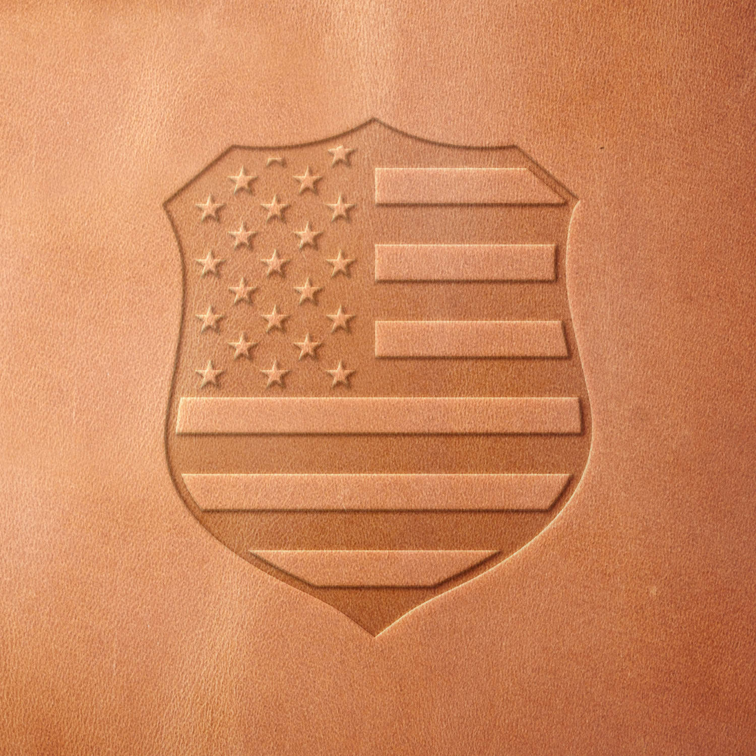 Leather sample showcasing a police badge with an American flag design, stamped with a Delrin leather stamp, representing patriotism and law enforcement pride.