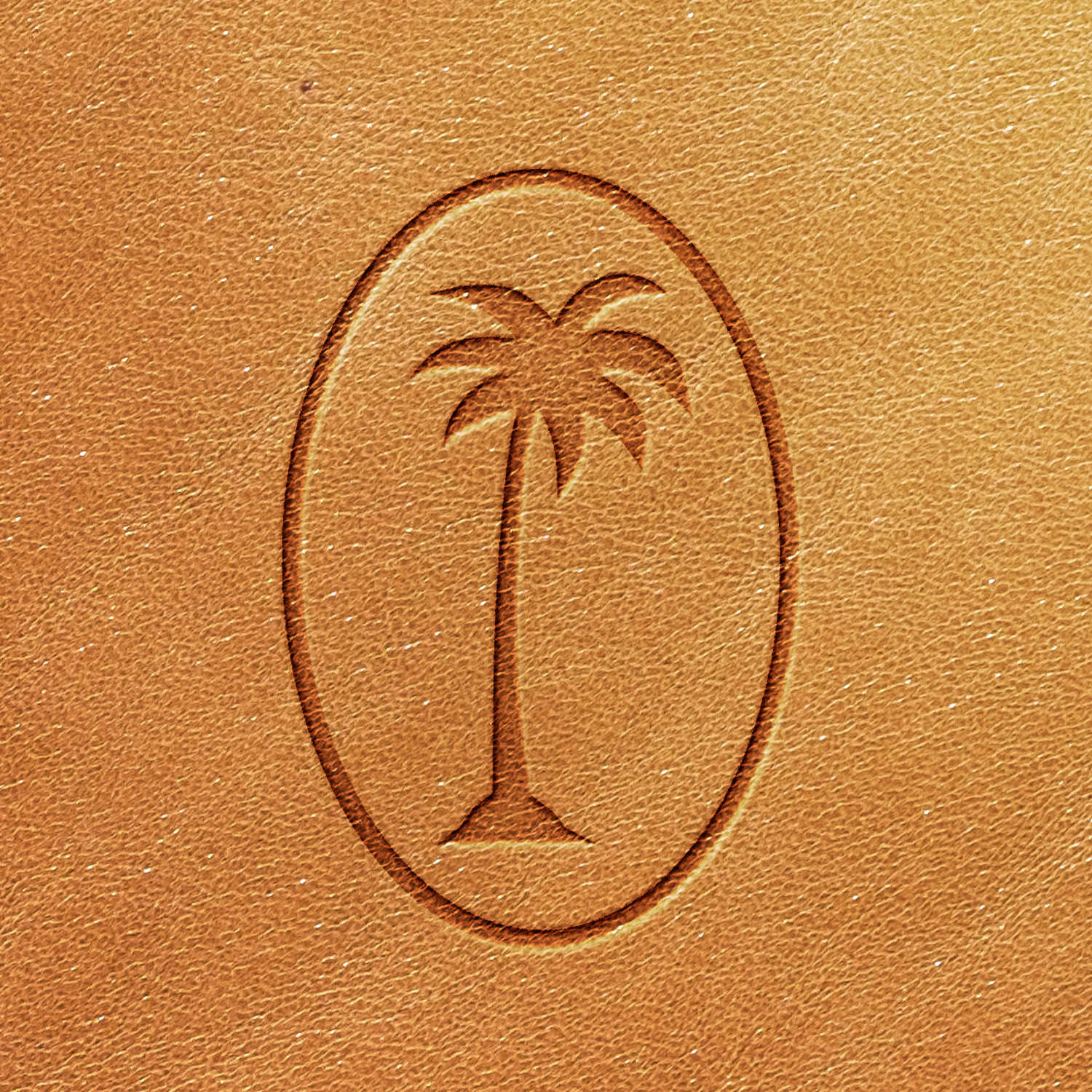 Embossed Palm Tree Delrin Leather Stamp logo within an oval on a brown leather surface.