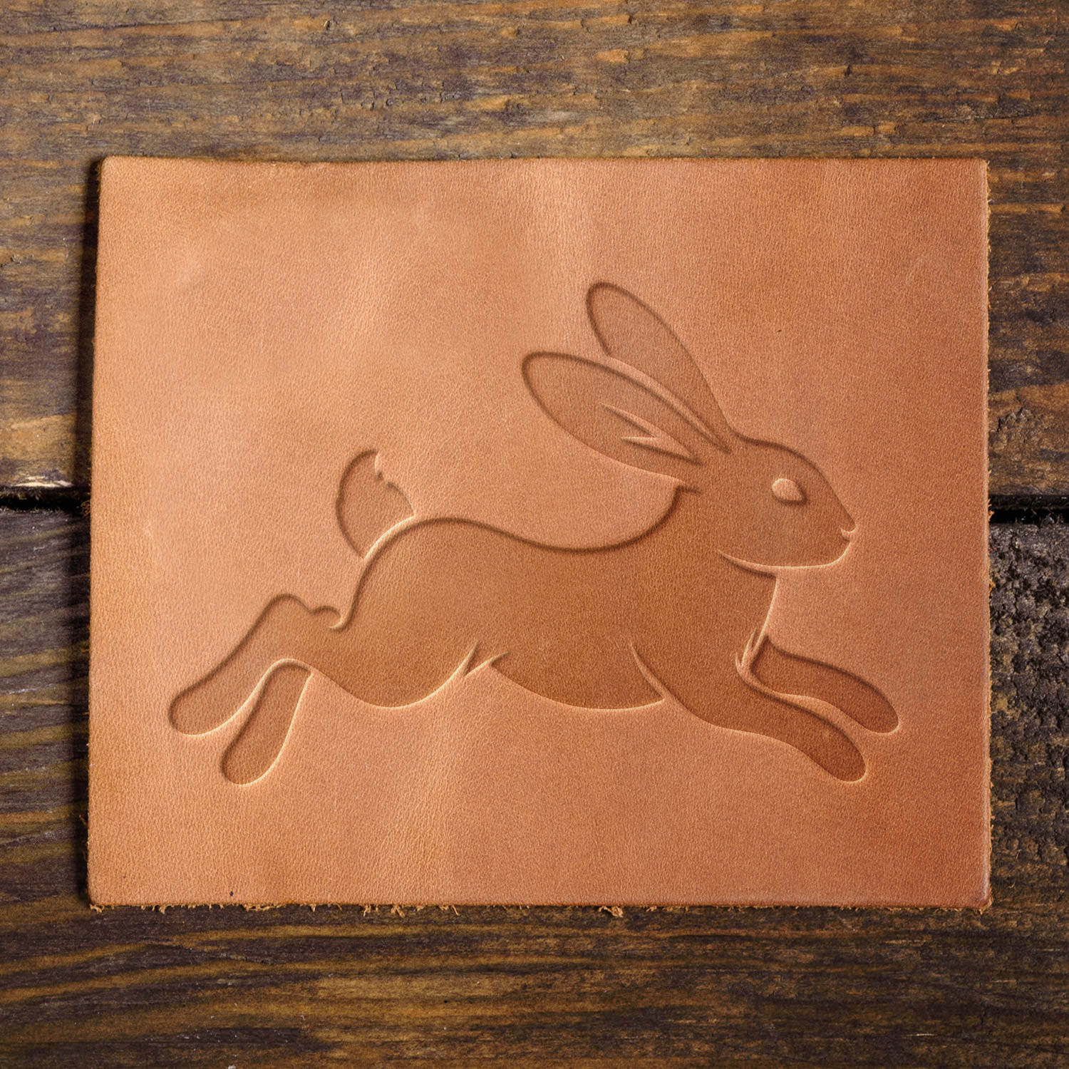 Leather sample with a stamped rabbit in mid-leap, ideal for animal and nature-themed leatherwork.