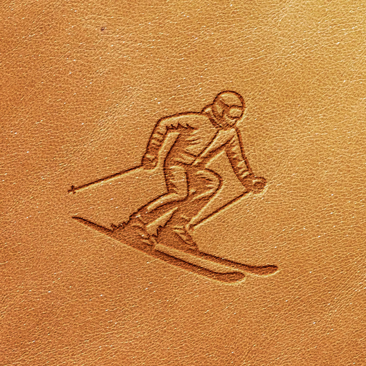 The Skier Delrin Leather Stamp features a detailed embossing of a skier in motion, complete with ski poles, skis, and motion lines. The skier is depicted wearing a helmet and ski suit against a warm brown leather background.