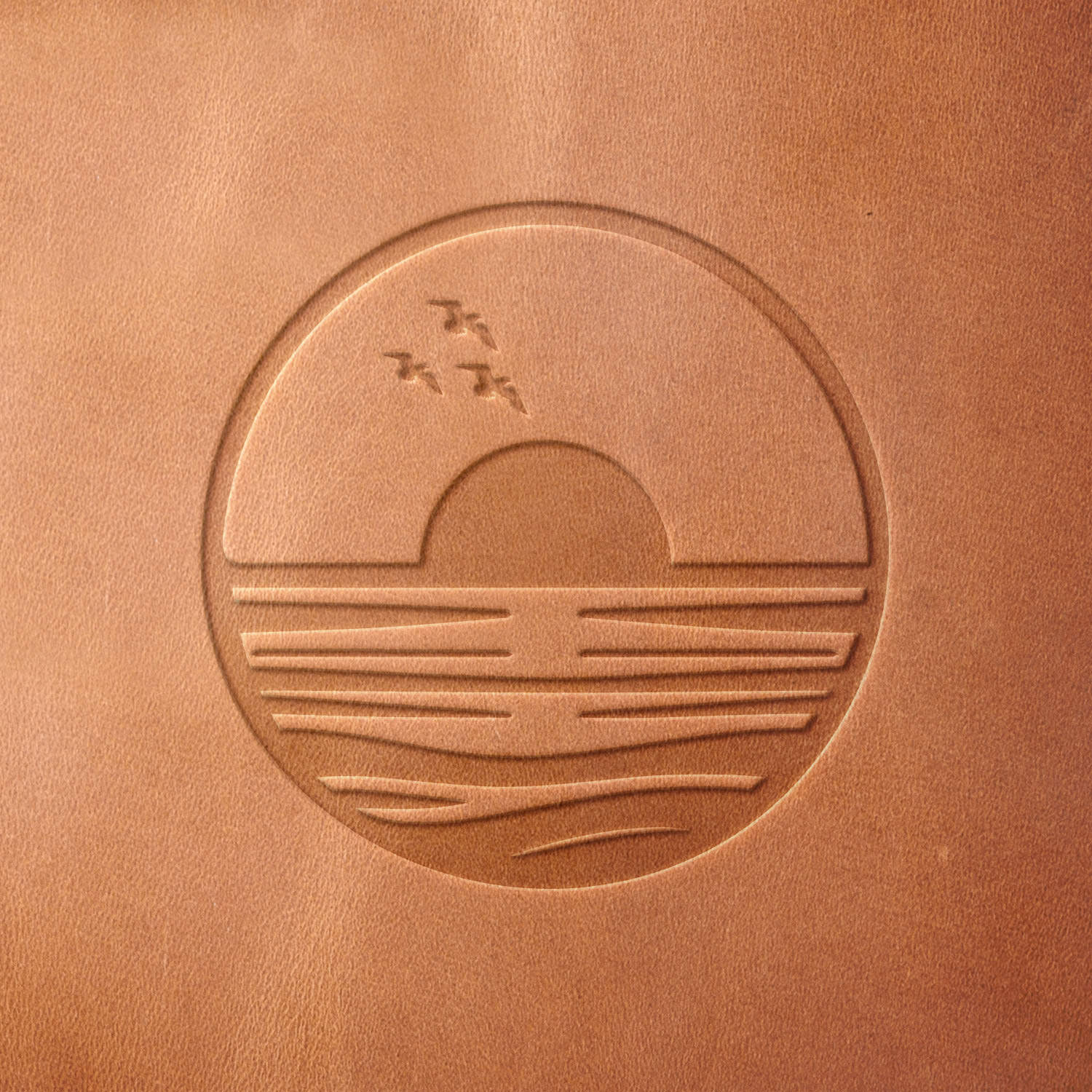 Leather sample with a crisp sunset over the ocean stamp impression from a Delrin leather stamp, ideal for creating high-quality beach and coastal-themed leathercraft projects.